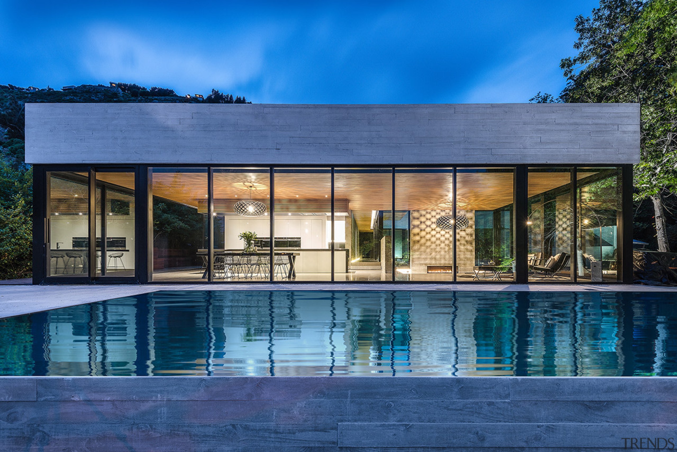 Seen from across the pool, this kitchen’s strong, architecture, corporate headquarters, estate, facade, home, house, property, real estate, reflection, residential area, sky, swimming pool, villa, water, window, blue