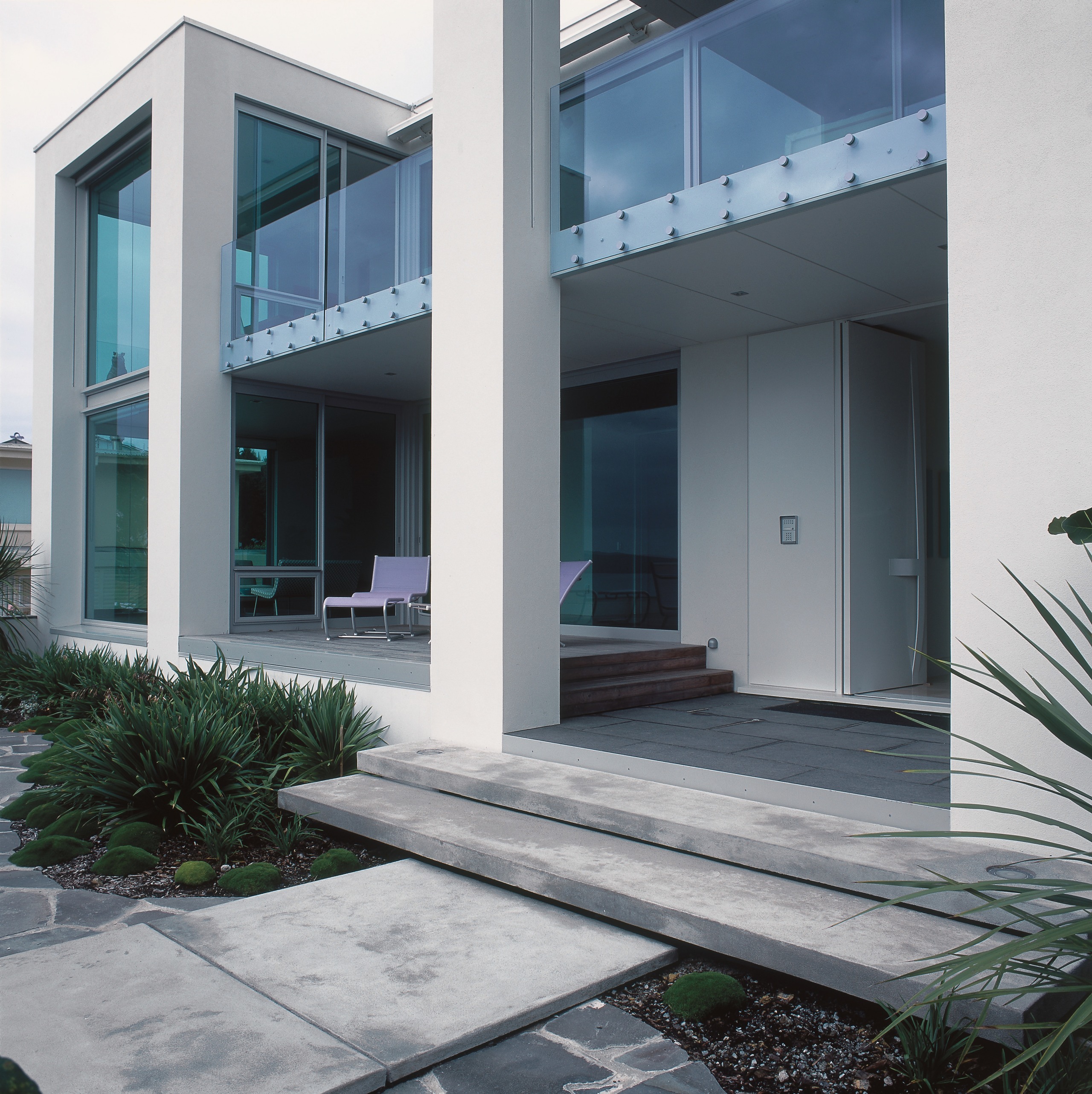 An exterior view of this clifftop house designed architecture, building, condominium, courtyard, door, facade, house, property, real estate, residential area, window, gray