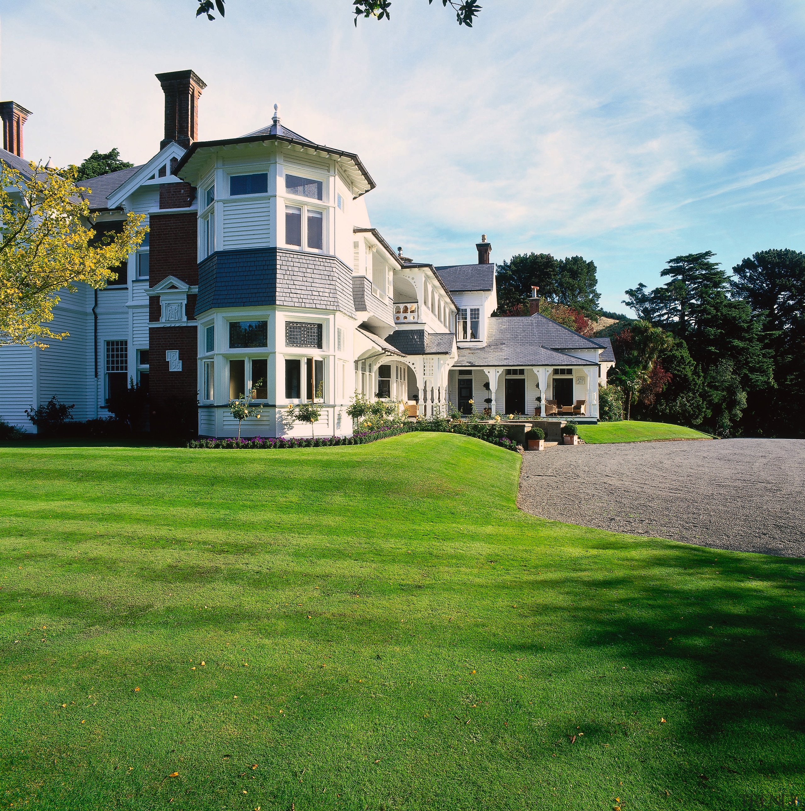 The view of a historical styled lodge - backyard, cottage, estate, facade, farmhouse, grass, home, house, land lot, landscape, landscaping, lawn, mansion, neighbourhood, plantation, property, real estate, residential area, sky, suburb, tree, villa, yard, green, white