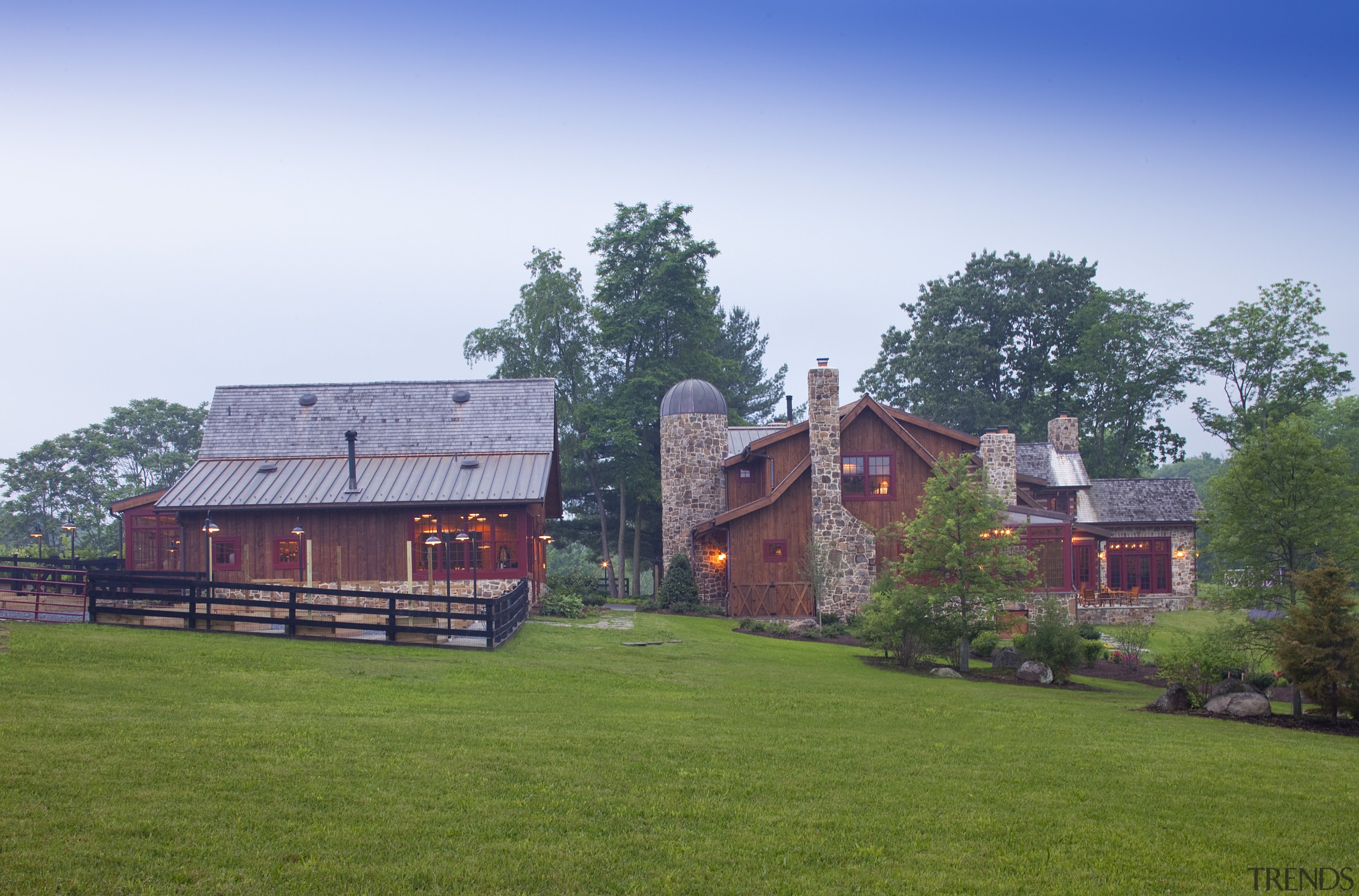View of two wooden buildings with lawn in barn, cottage, estate, farm, farmhouse, field, grass, home, house, land lot, landscape, lawn, manor house, meadow, pasture, plant, property, real estate, residential area, rural area, sky, suburb, tree, village, white