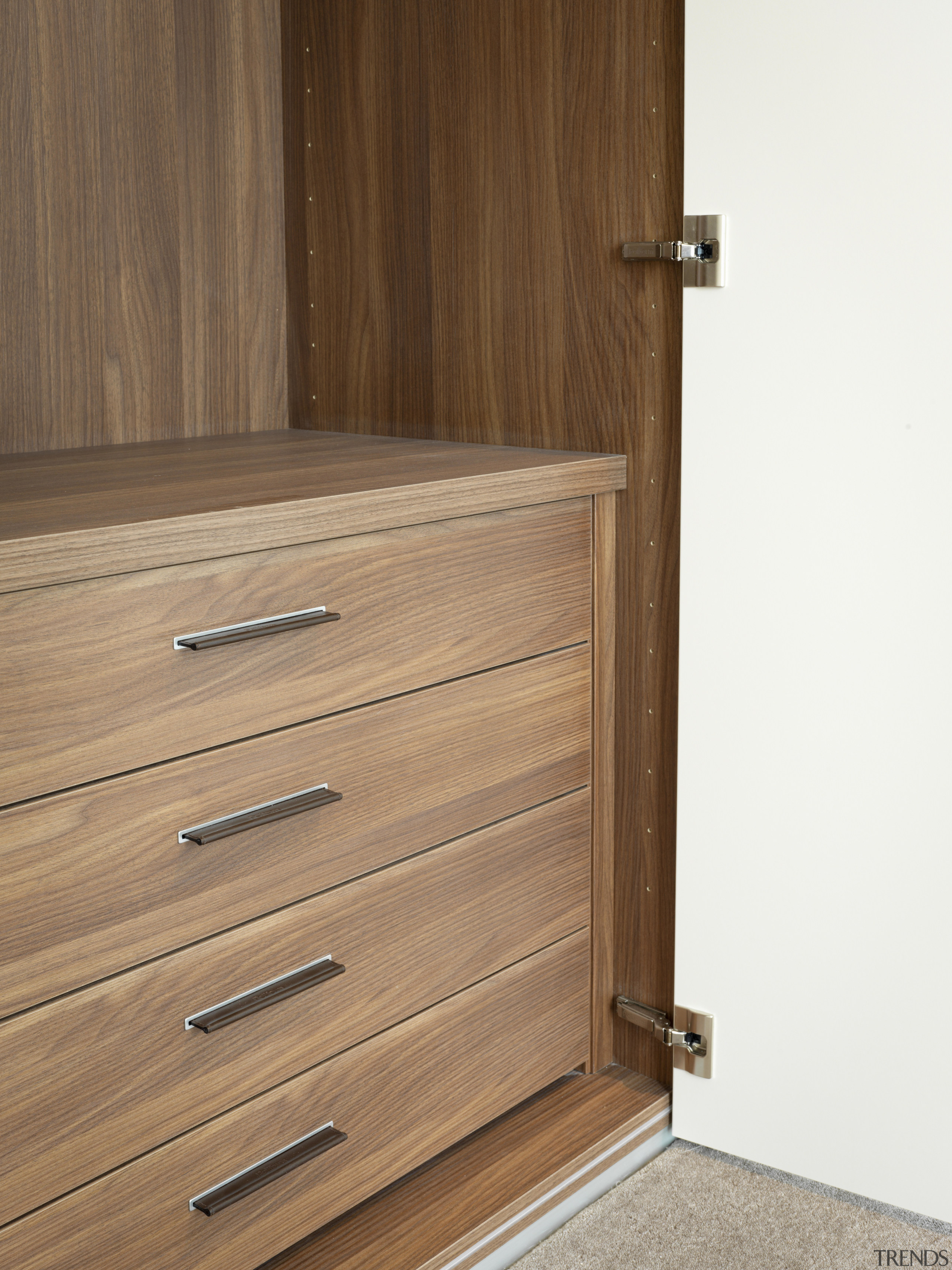 View of an apartment which features cabinetry by chest of drawers, door, drawer, furniture, hardwood, wood, wood stain, brown, white