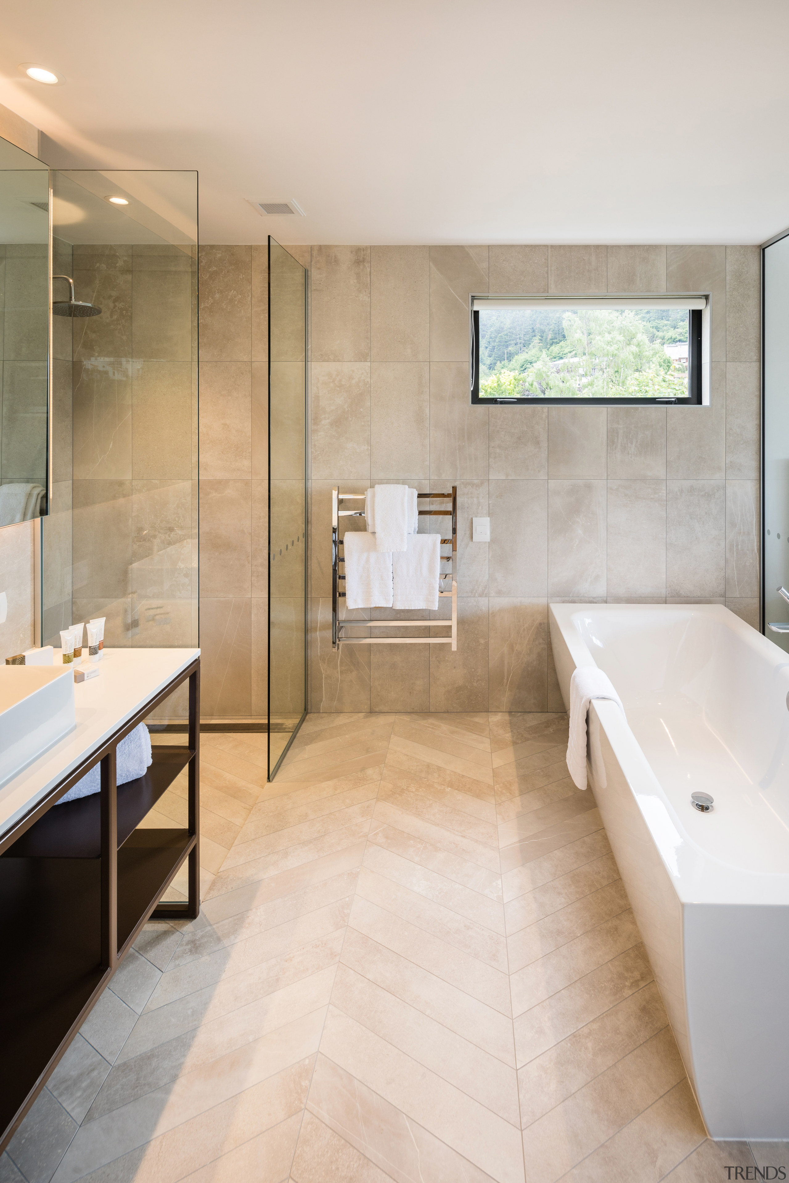 ​​​​​​​Clean-lined and contemporary, this custom steel-framed vanity is architecture, bathroom, bathtub, beige, building, ceiling, floor, flooring, furniture, home, house, interior design, plumbing fixture, property, real estate, room, sink, tile, wall, gray