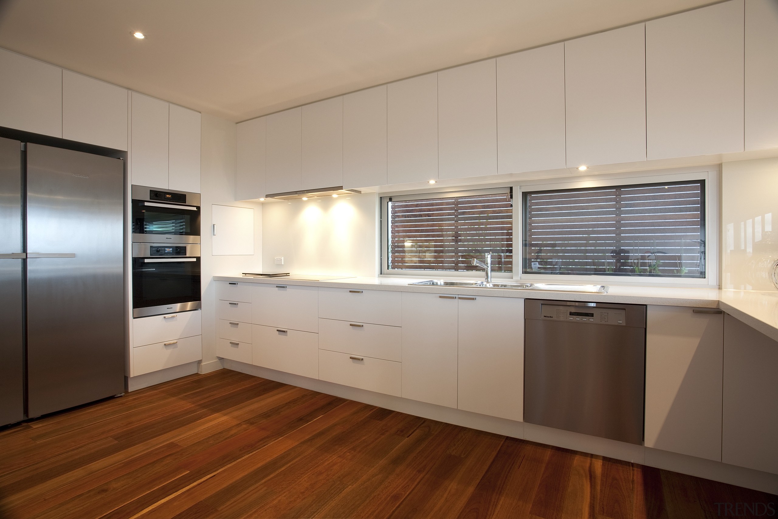 Kitchen with wooden flooring, white drawers and stainless cabinetry, countertop, floor, flooring, hardwood, interior design, kitchen, real estate, room, wood, wood flooring, gray, brown