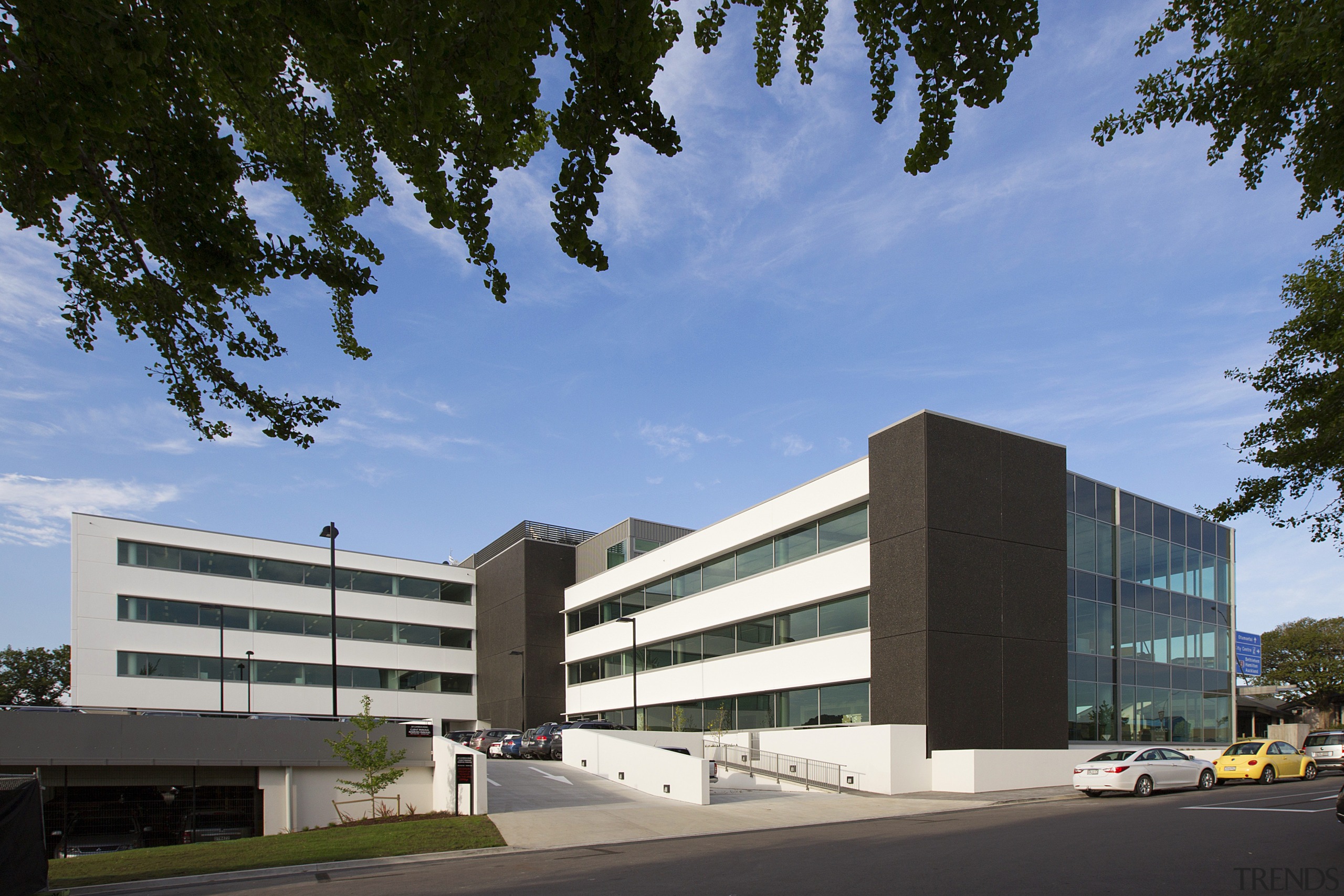 The west facade of ANZ Tauranga features precast architecture, building, campus, commercial building, condominium, corporate headquarters, daytime, elevation, facade, headquarters, metropolitan area, mixed use, real estate, residential area, sky, teal, black