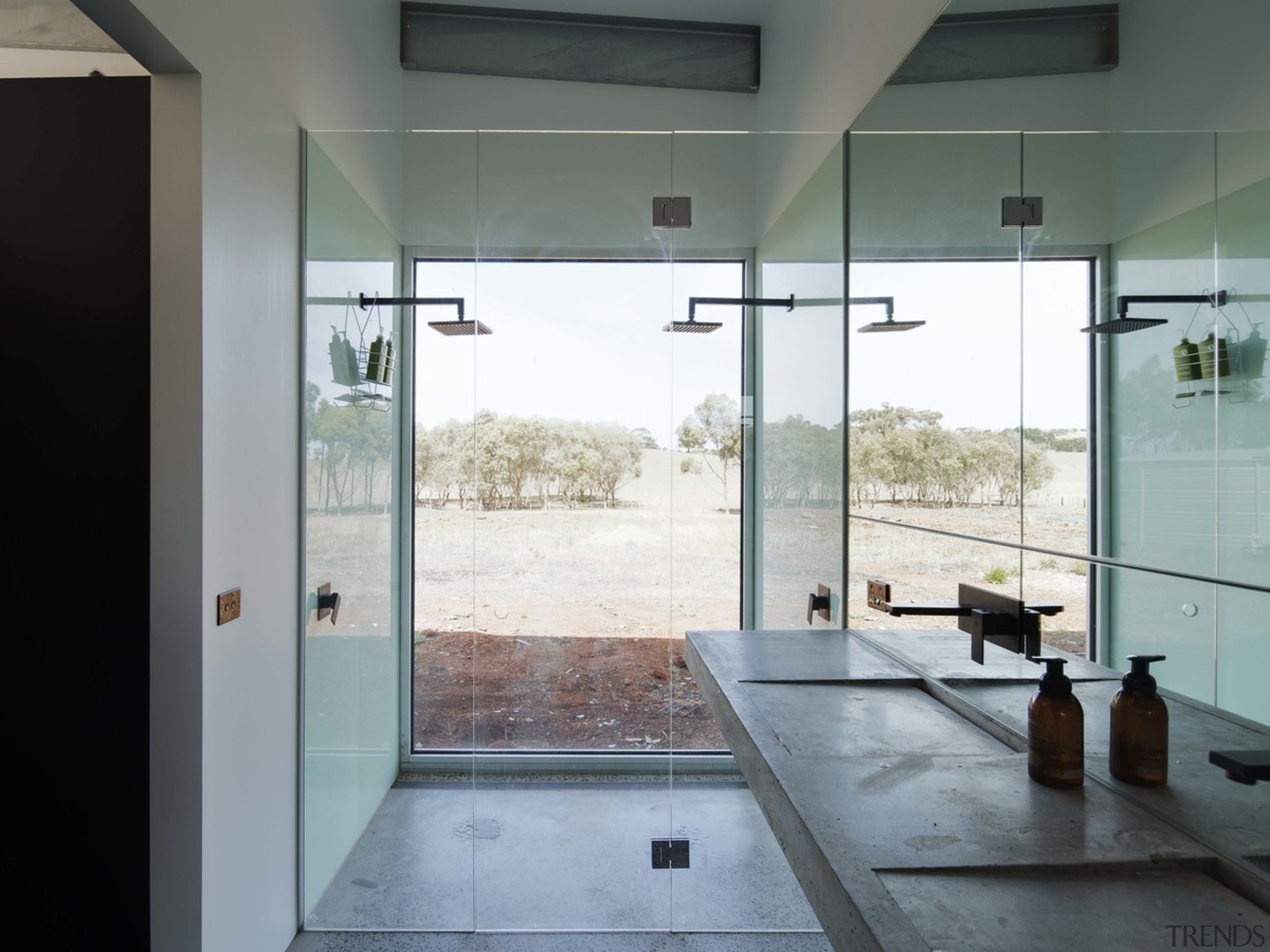 The double shower lacks privacy, but makes up architecture, bathroom, door, floor, flooring, glass, house, interior design, plumbing fixture, room, tile, gray