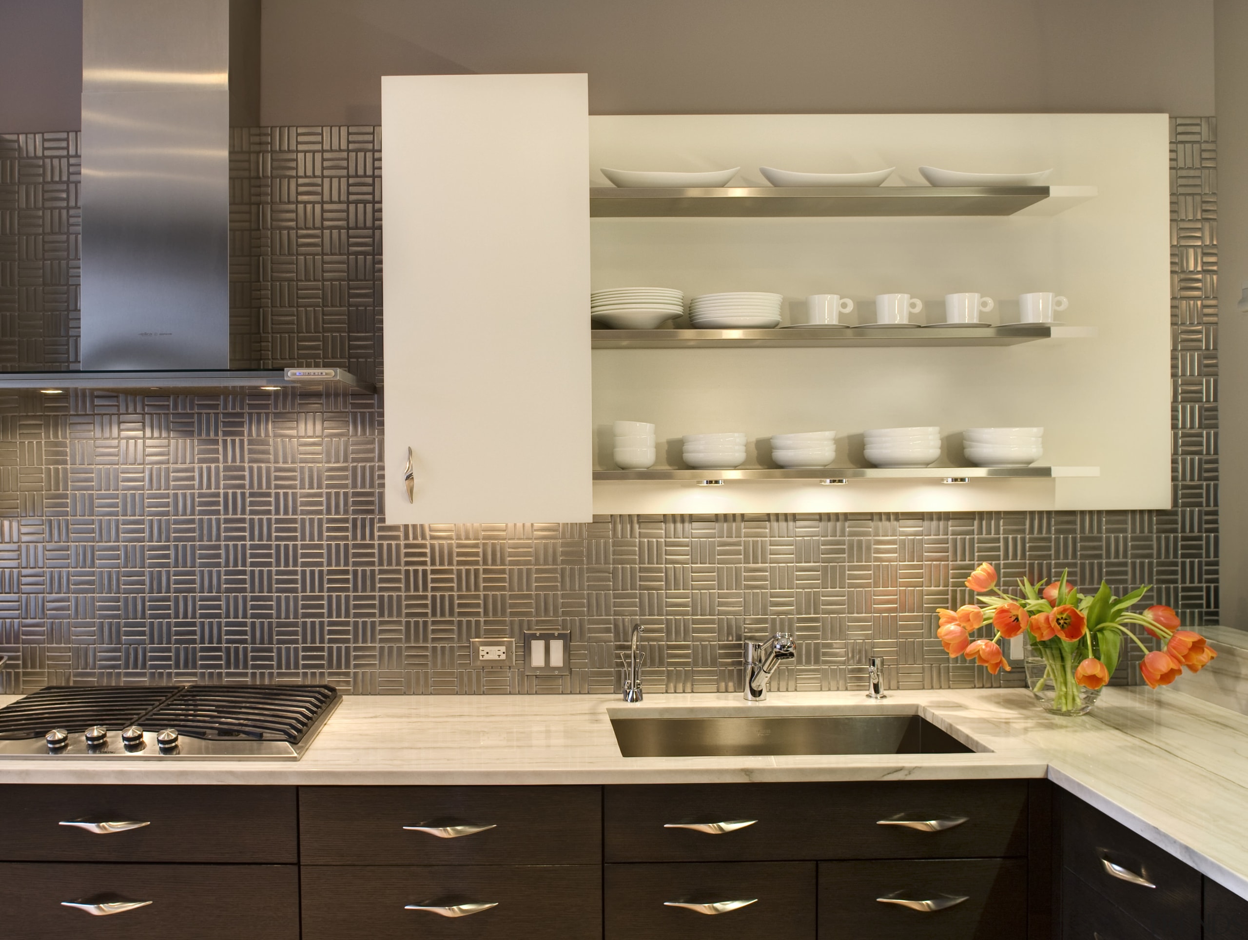 View of the textured stainless steel backsplash, cabinetry, bathroom, cabinetry, countertop, flooring, interior design, kitchen, sink, tile, under cabinet lighting, brown, orange