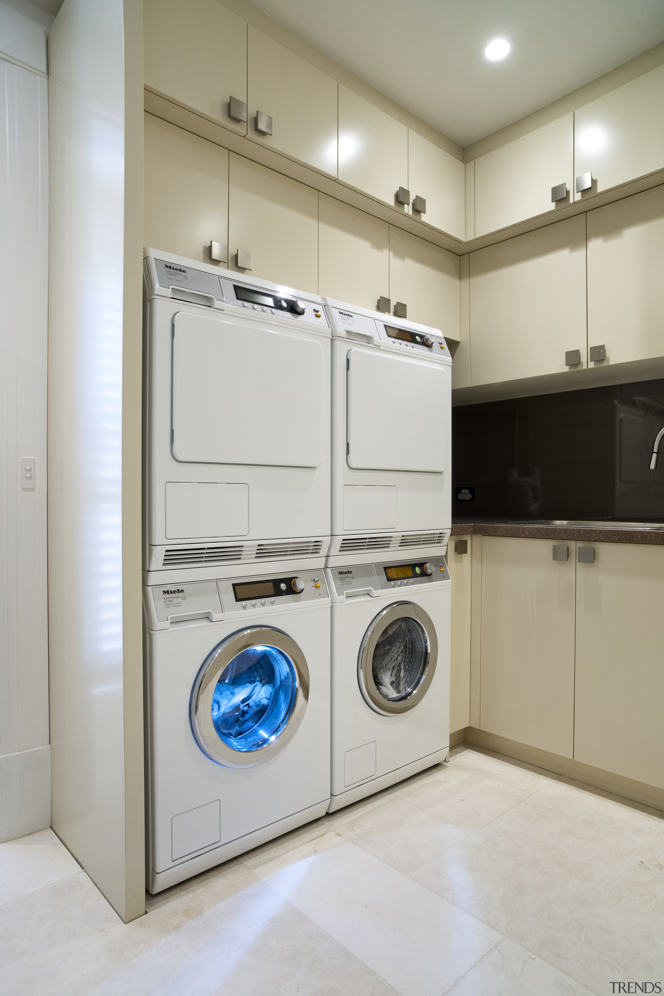 Laundry with cream cupboards and stacked dryer and clothes dryer, home appliance, laundry, laundry room, major appliance, product design, room, washing machine, gray
