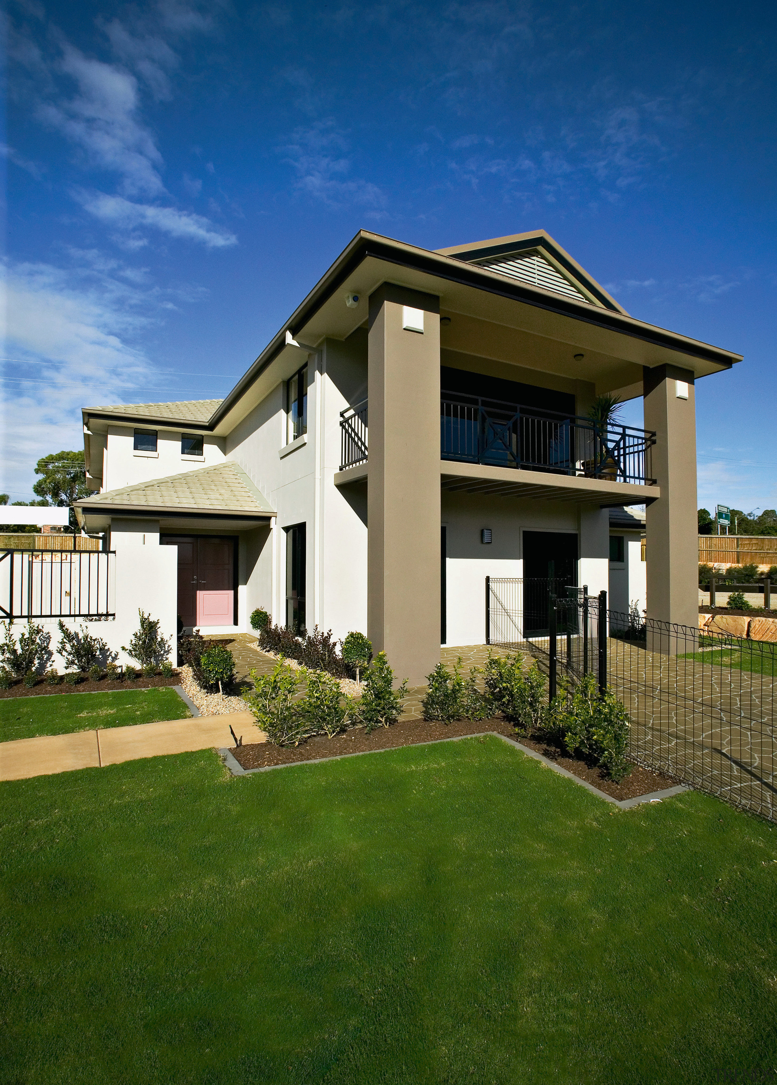 Exterior view of two-storey home with cream and architecture, building, cottage, elevation, estate, facade, grass, home, house, property, real estate, residential area, roof, sky, villa, brown, blue