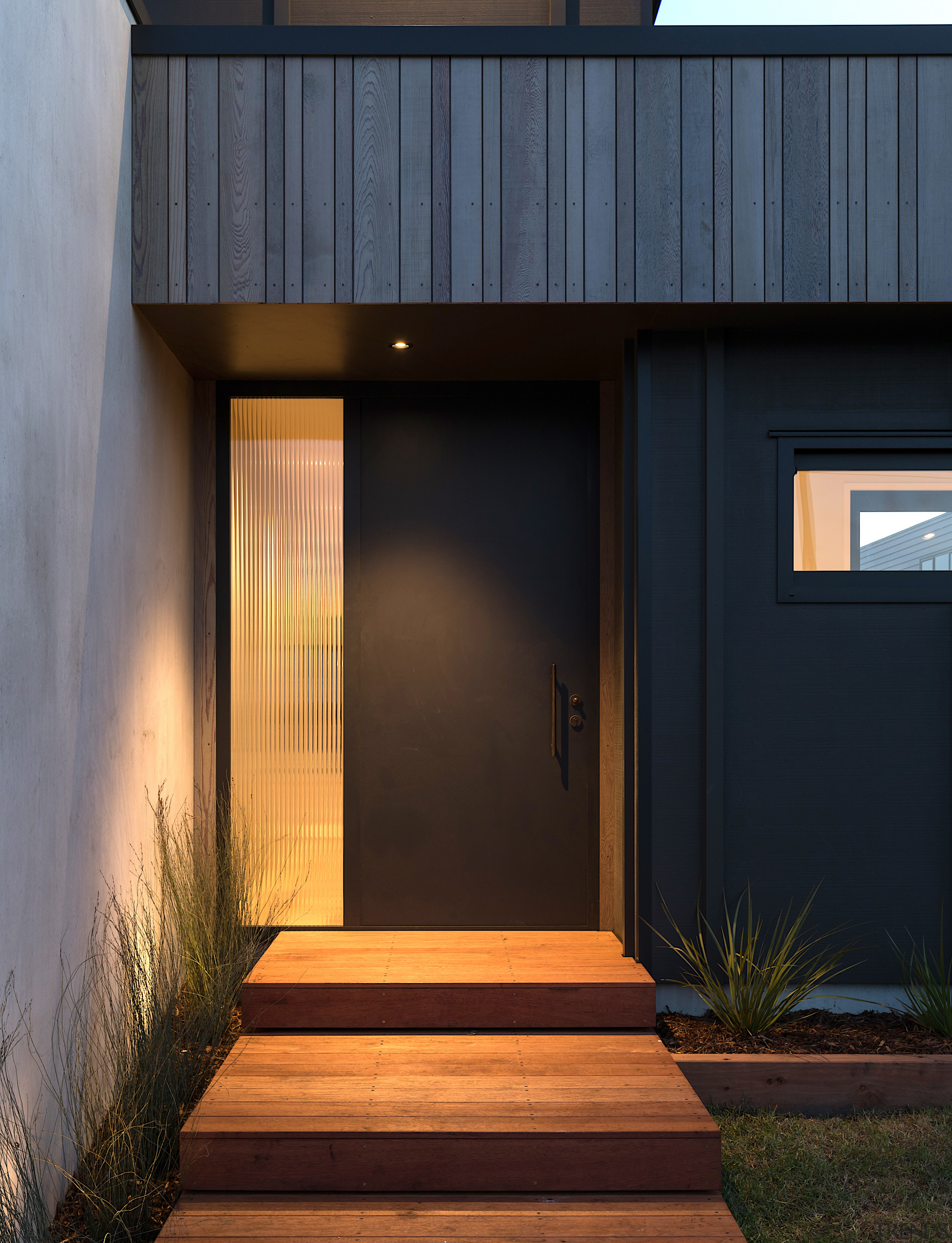 Entry into the home is alongside a concrete 