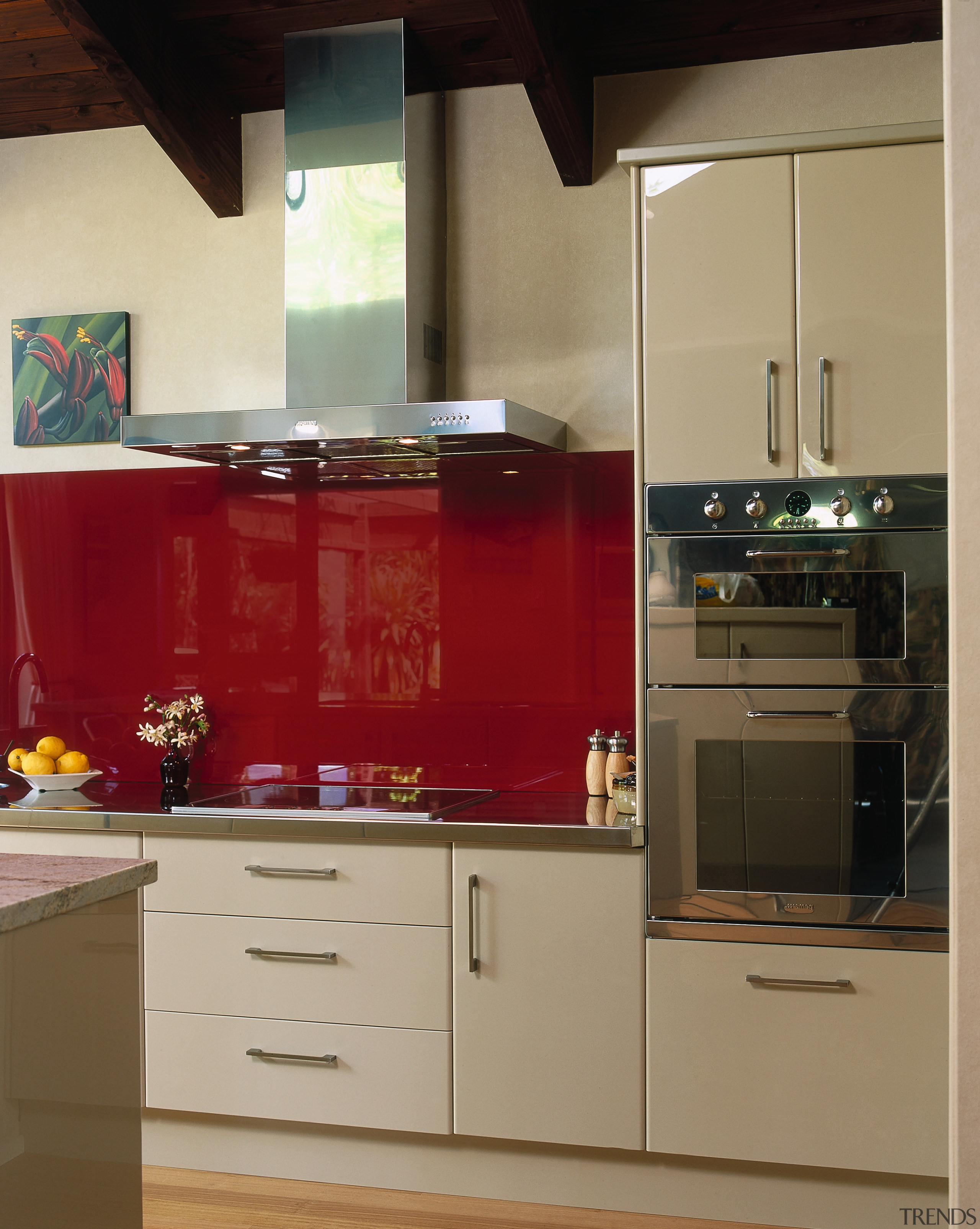 Kitchen with cream cabinetry, red splashback and stainless cabinetry, countertop, cuisine classique, furniture, home appliance, interior design, kitchen, kitchen stove, room, brown, orange