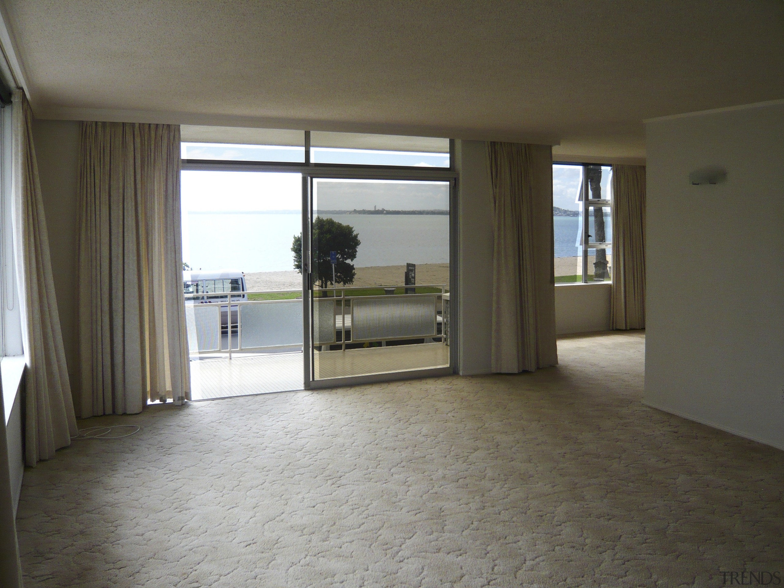 Image of the living room prior to renovations. apartment, floor, flooring, home, house, interior design, property, real estate, room, window, wood flooring, brown, gray