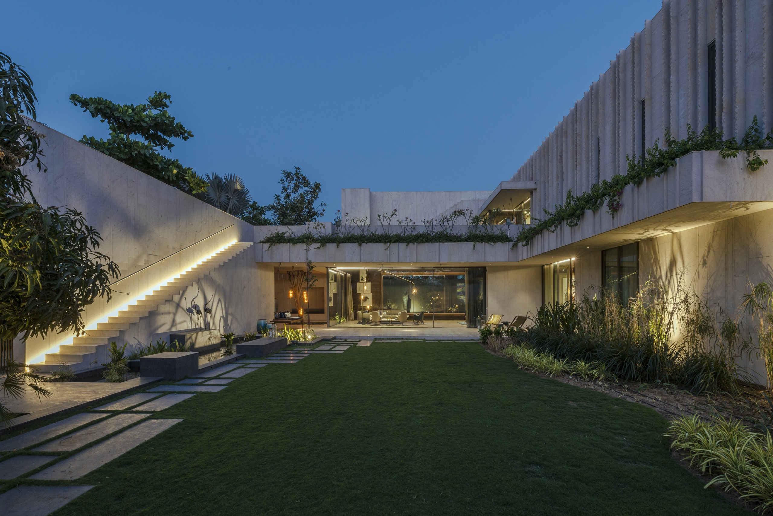 The house of secret gardens by night, with architecture, building, courtyard, estate, facade, grass, home, house, landscaping, mansion, property, real estate, residential area, sky, black, blue