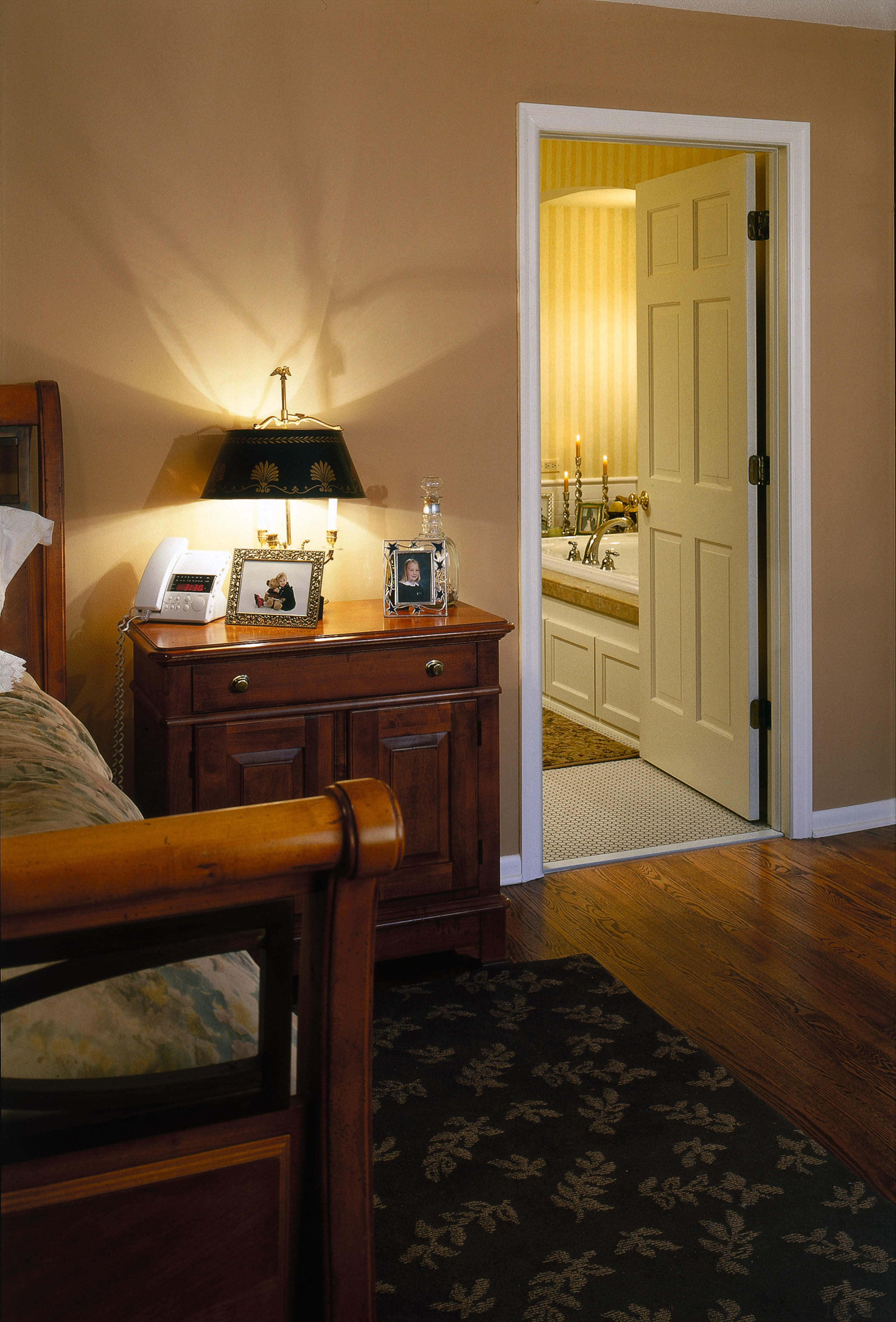 View of the bedroom by the bathroom - bedroom, door, floor, flooring, furniture, hardwood, home, interior design, room, suite, wood, wood flooring, brown, black