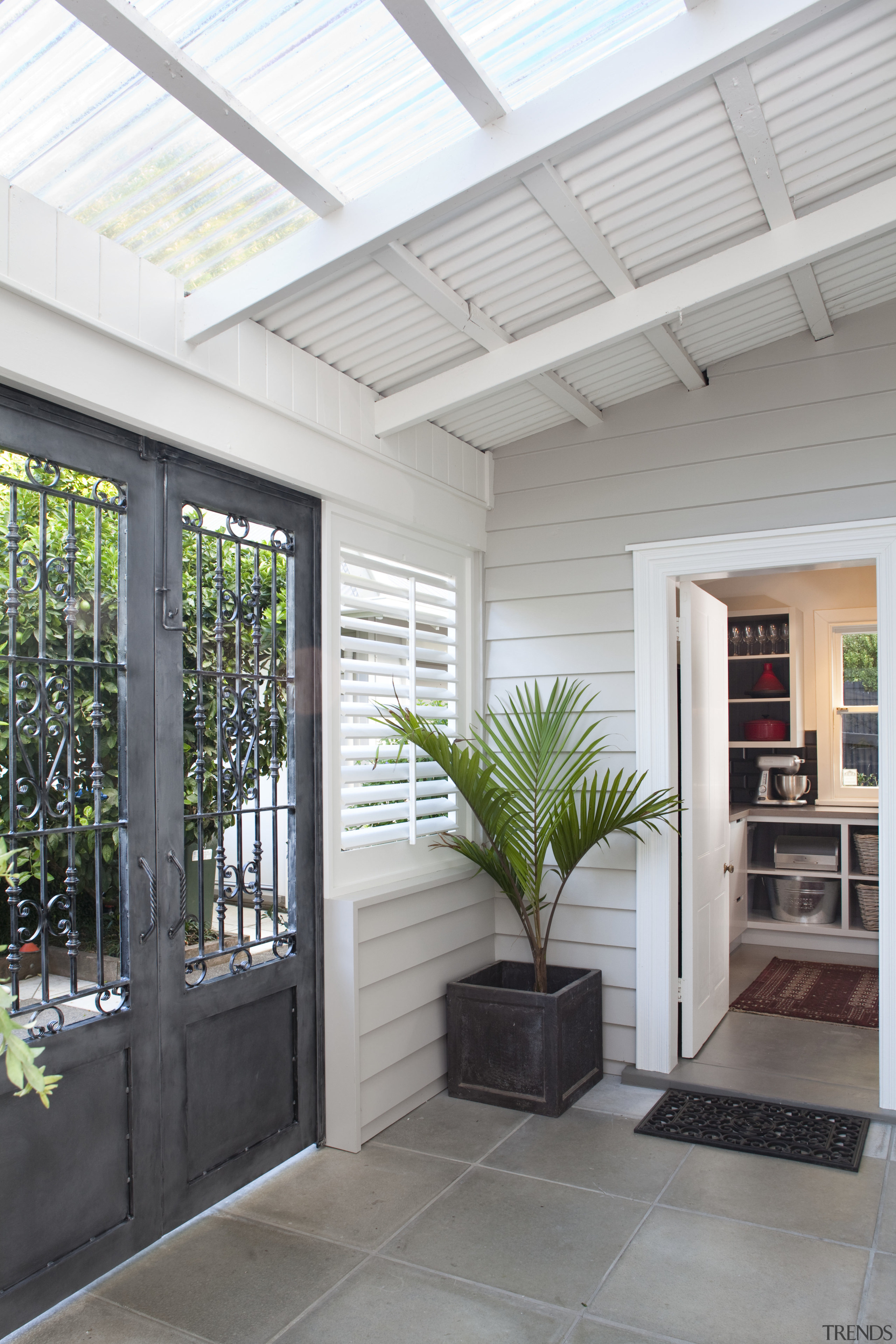 outside area, stone tiles, plant in corner, grey ceiling, courtyard, daylighting, home, house, interior design, outdoor structure, real estate, roof, window, white, gray
