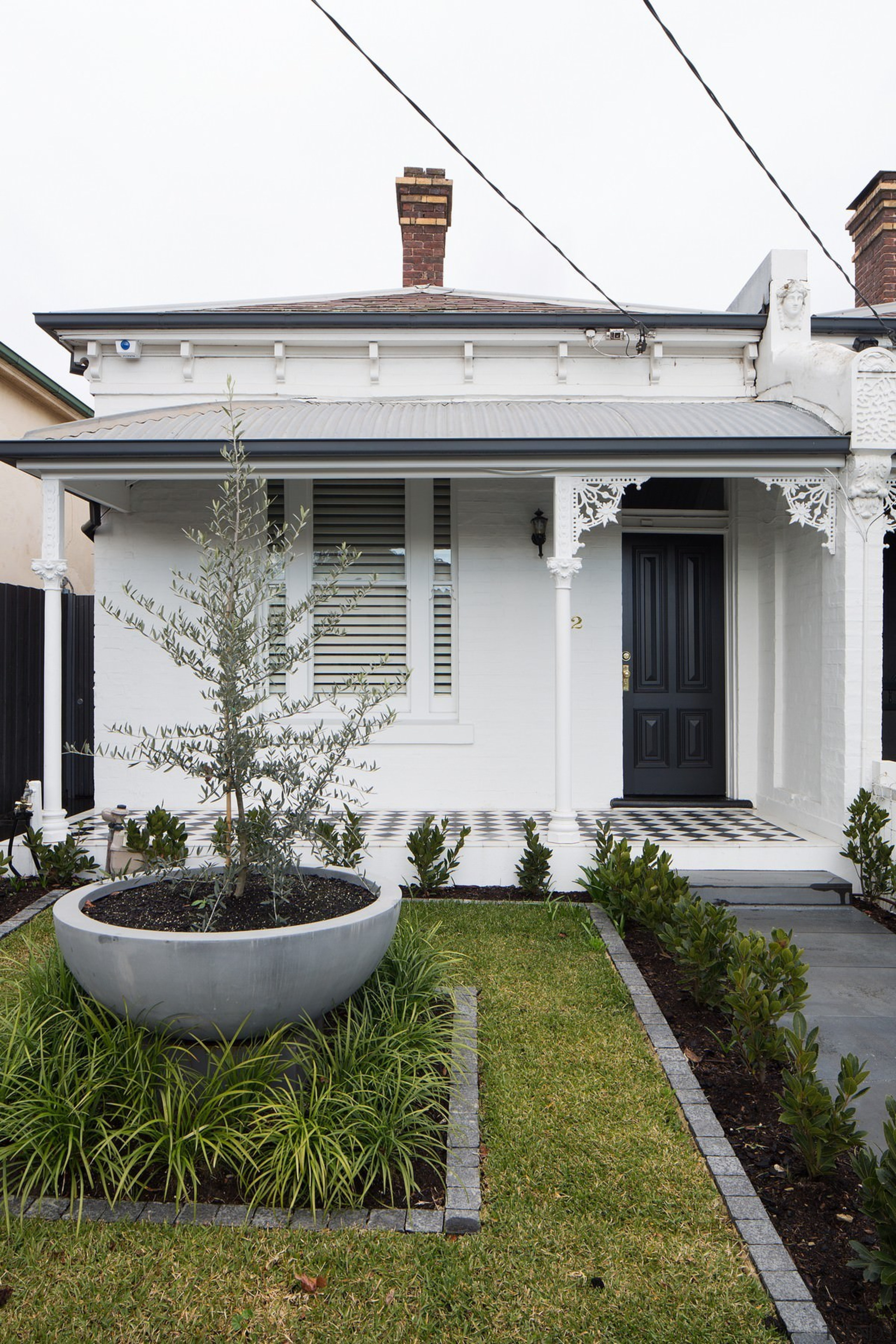 From the street, only subtle changes hint at architecture, backyard, facade, home, house, outdoor structure, property, real estate, residential area, window, yard, white