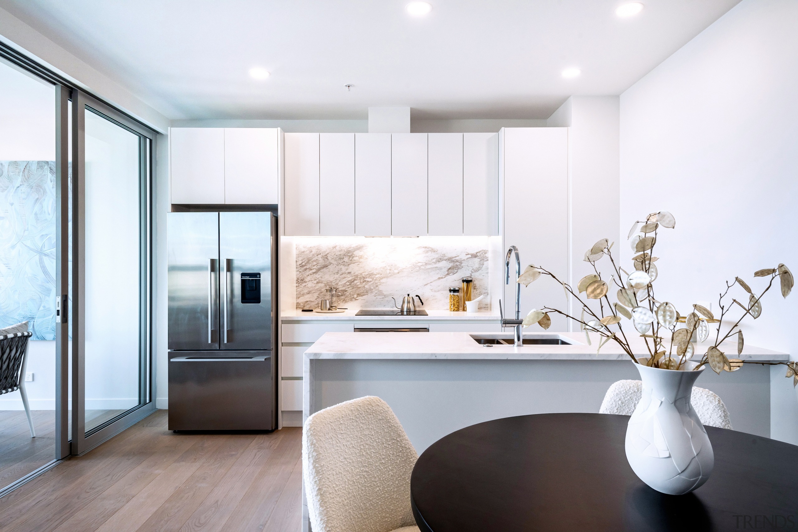 A spacious apartment kitchen with marble benchtops and 