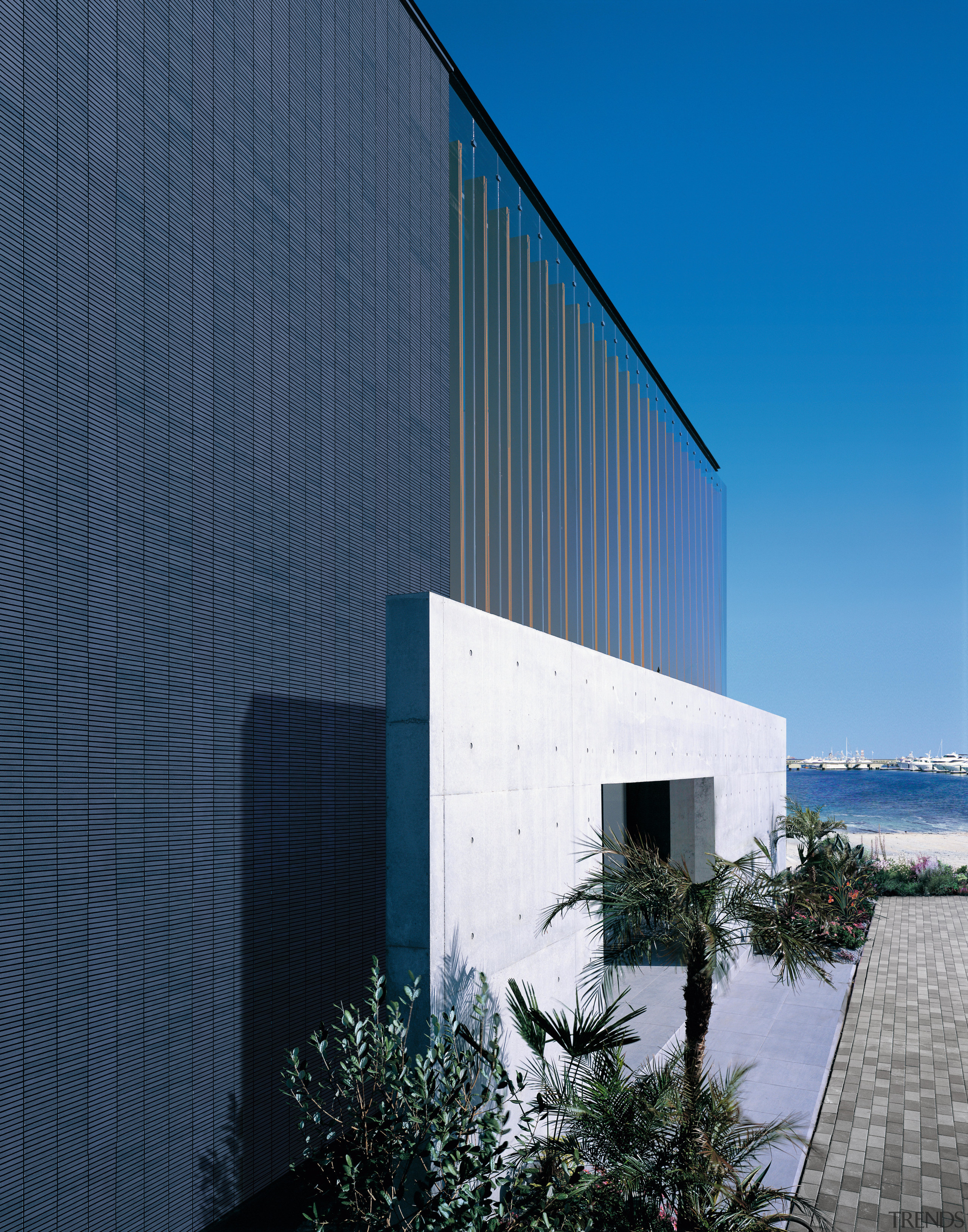 The layered facade of this oceanfront house in architecture, building, commercial building, corporate headquarters, daylighting, facade, headquarters, house, real estate, reflection, sky, blue