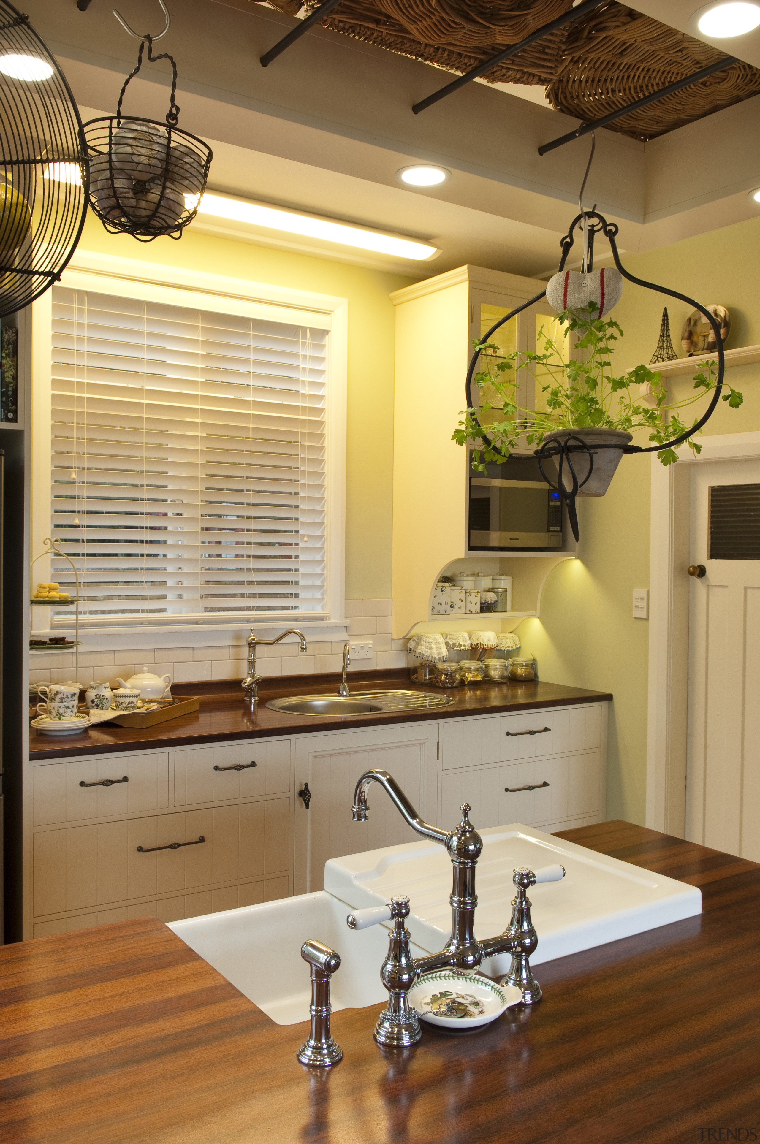 white sink integrated into island, hanging pot plants ceiling, countertop, home, interior design, kitchen, lighting, room, under cabinet lighting, window, brown, orange