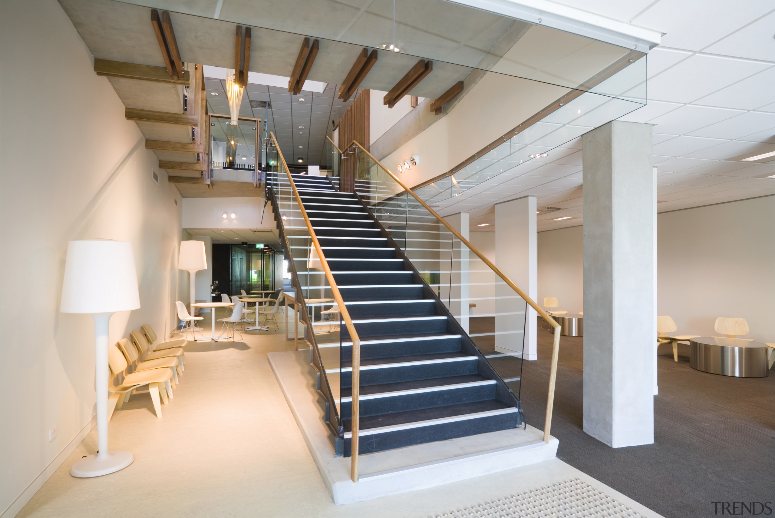 A view of the staircase featuring glass balustrading architecture, ceiling, daylighting, handrail, interior design, lobby, real estate, stairs, gray