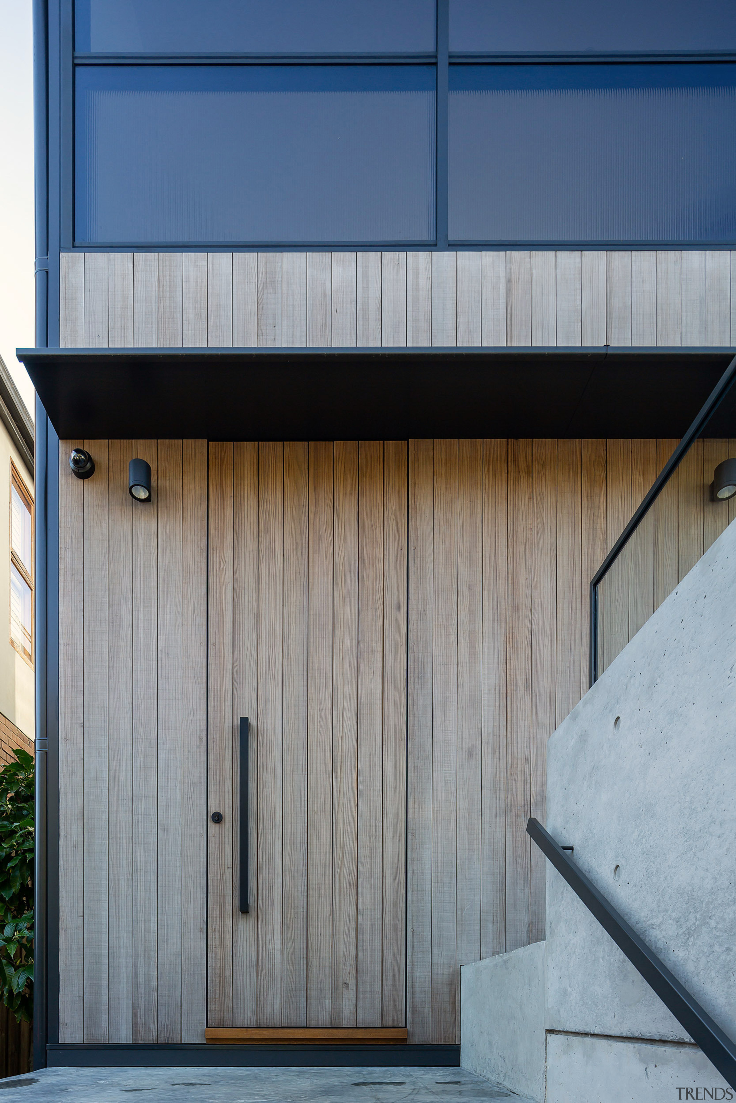 An understated front door disappears into the cladding. 