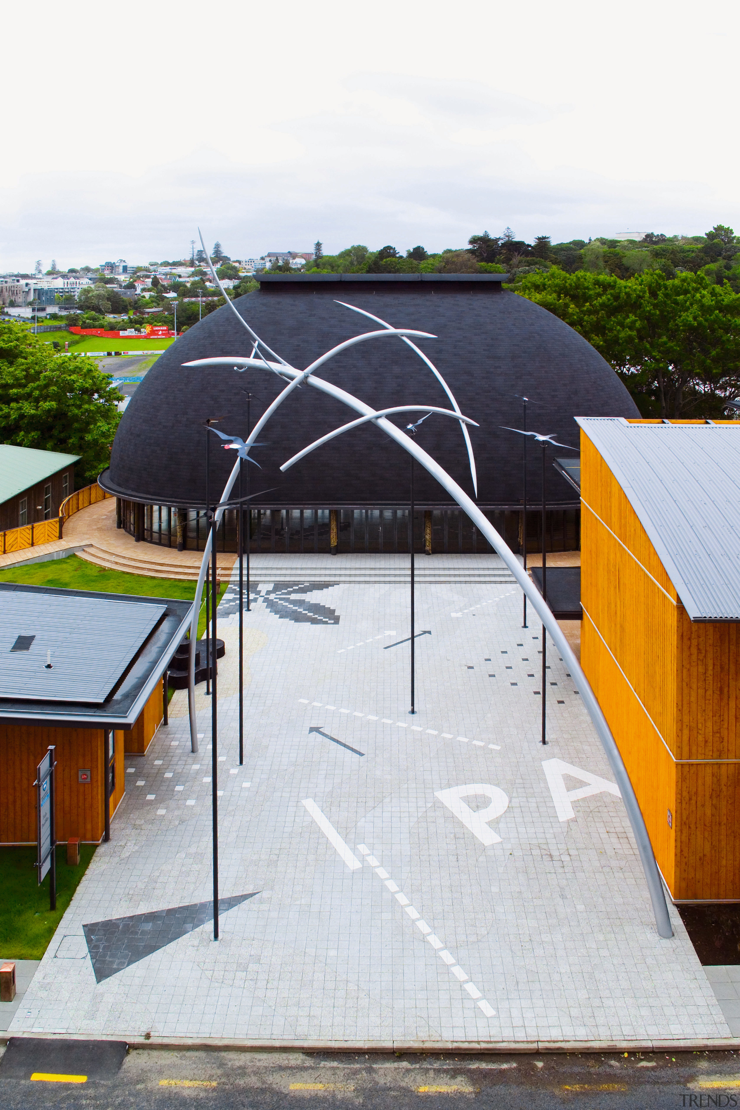 Paved area between buildings with tall sculpture, timber architecture, daylighting, facade, house, roof, shed, structure, white