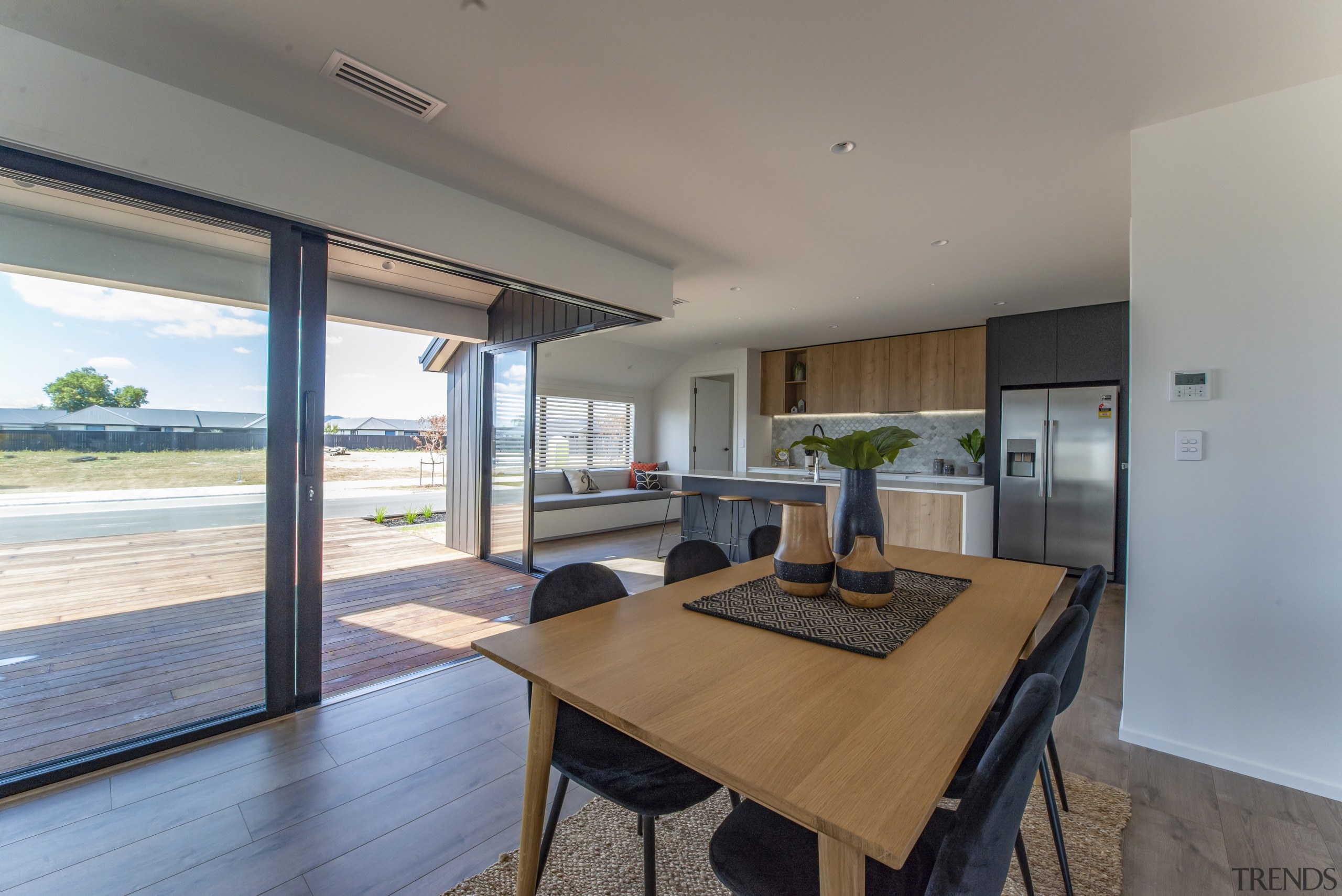​​​​​​​In this Fowler Homes Waikato showhome corner sliders apartment, architecture, building, ceiling, daylighting, dining room, estate, floor, flooring, furniture, hardwood, home, house, interior design, laminate flooring, property, real estate, residential area, room, table, window, wood, wood flooring, gray
