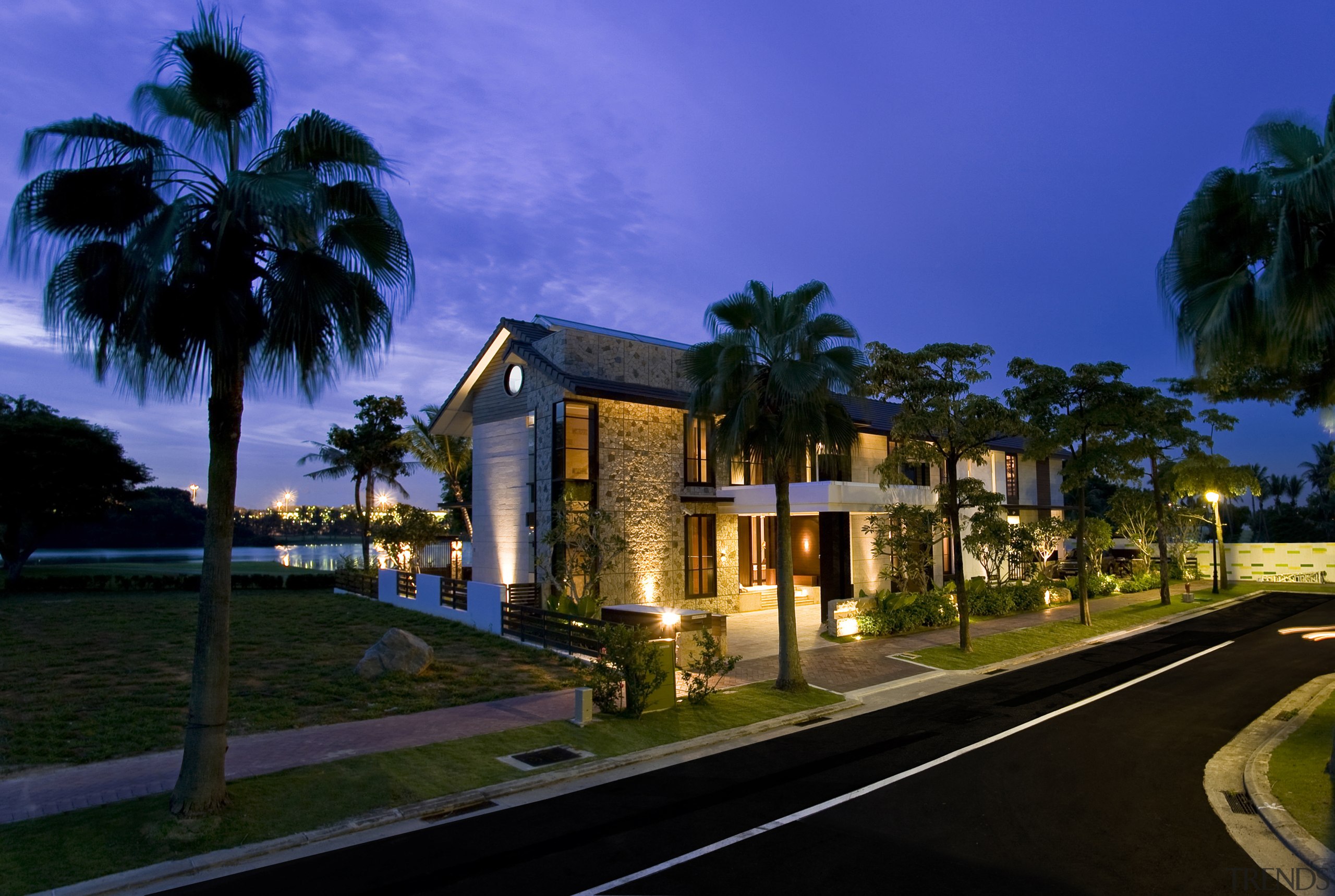 Exterior view of house which features a gabled architecture, arecales, condominium, estate, evening, home, hotel, house, landscape lighting, leisure, lighting, mansion, night, palm tree, property, real estate, resort, sky, villa, blue, black
