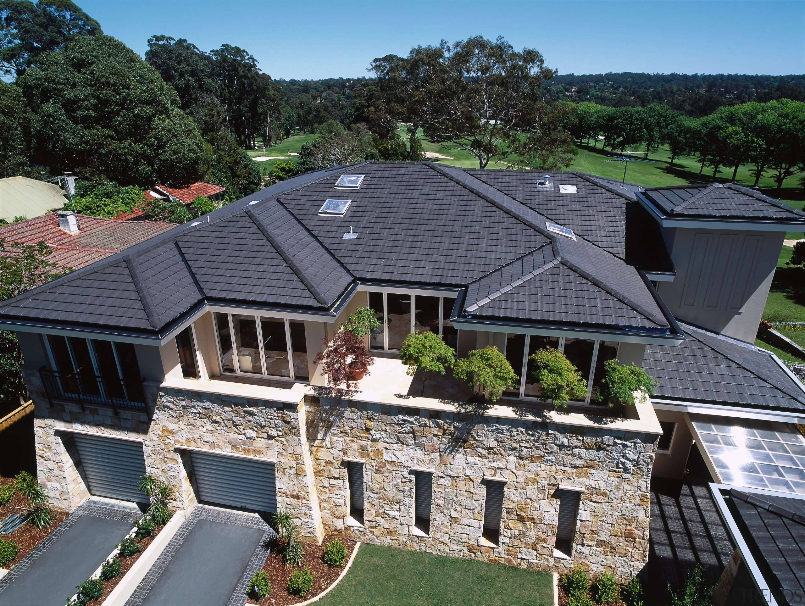 Exterior view of apartment complex with grey concrete cottage, estate, facade, home, house, mansion, outdoor structure, property, real estate, residential area, roof, suburb, black