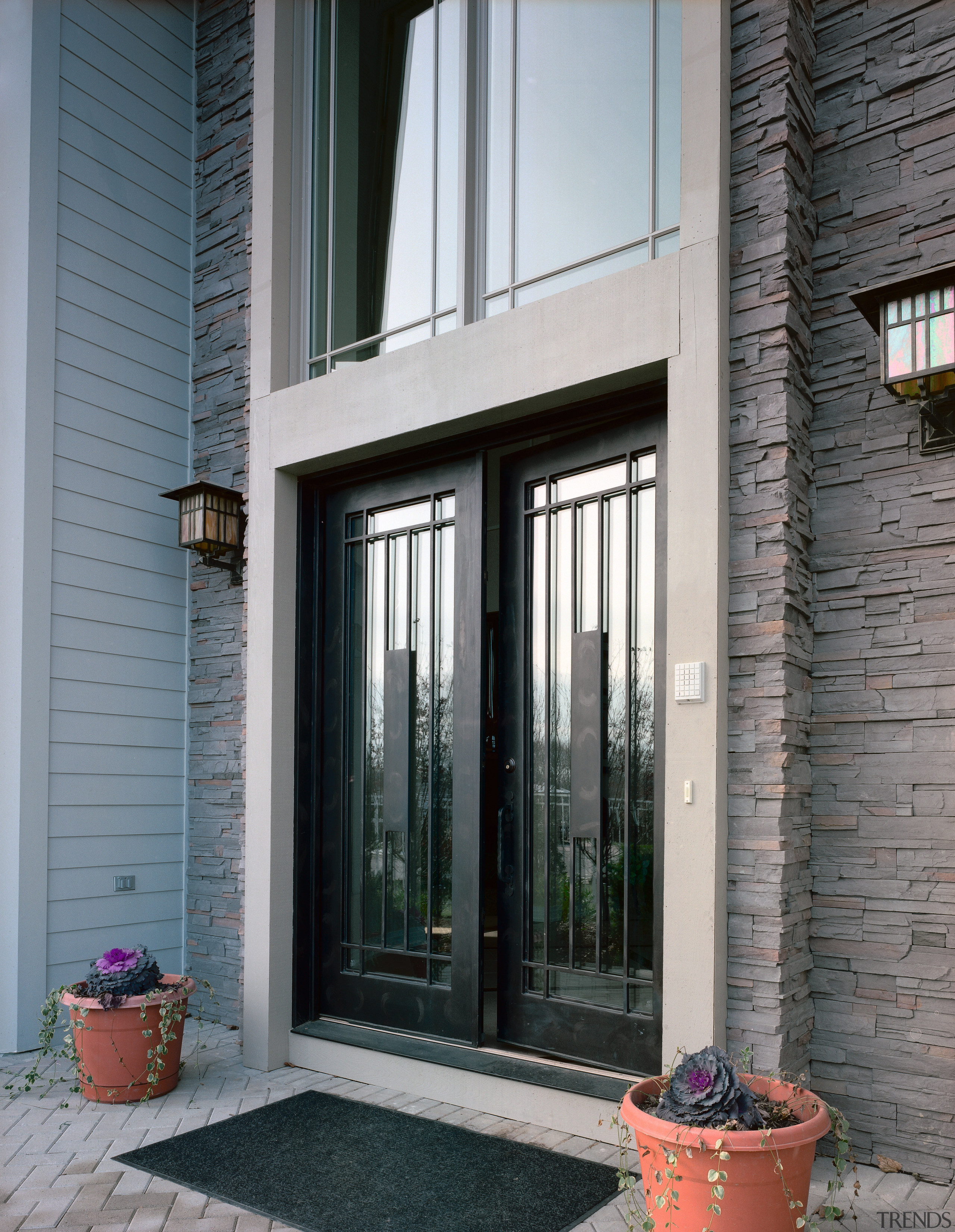 Exterior view of apartment entranceway showing glass and door, facade, home, house, porch, real estate, sash window, siding, window, gray, black