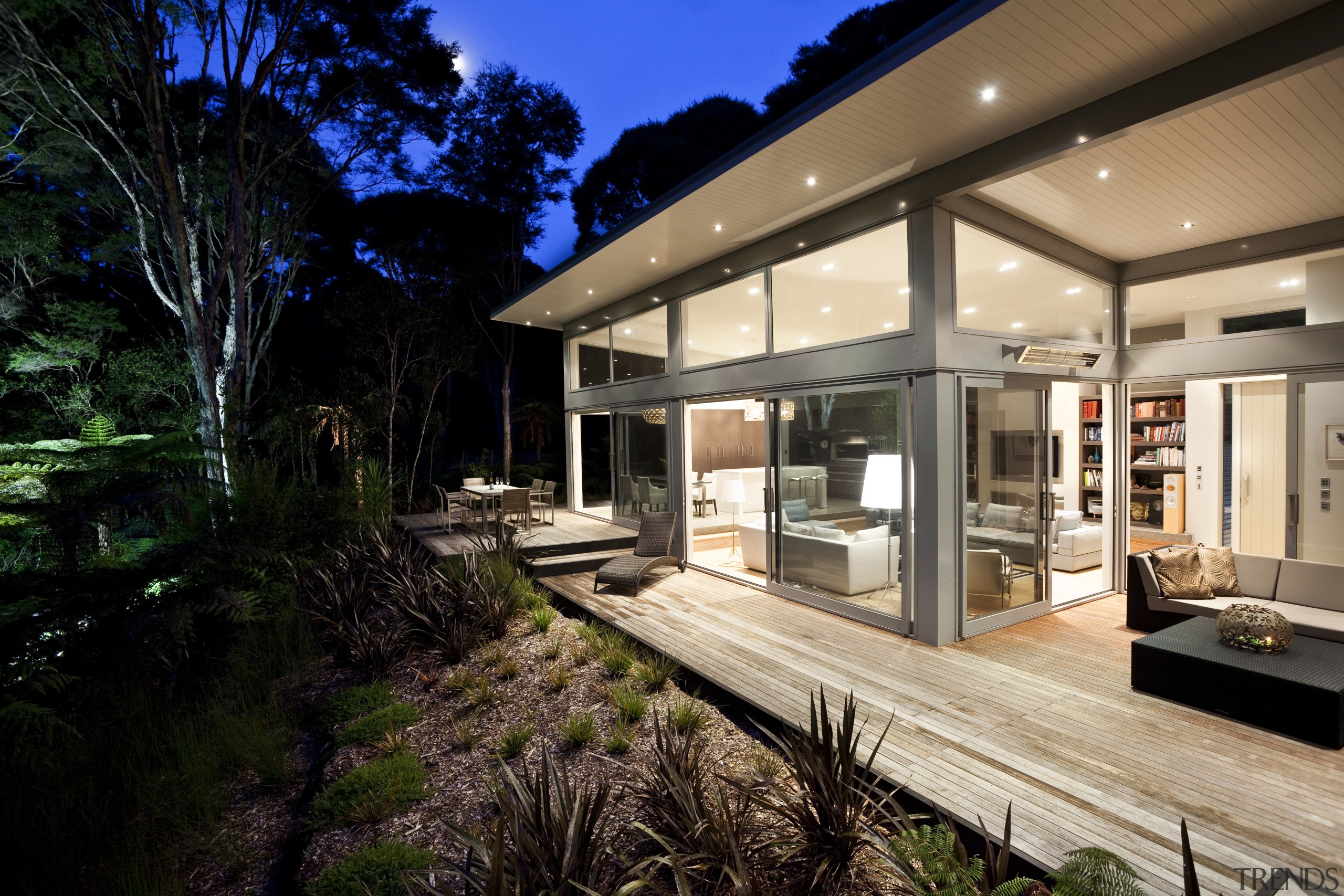 Nighttime shot of contemporary home surrounded by trees. architecture, backyard, estate, home, house, interior design, property, real estate, window, black