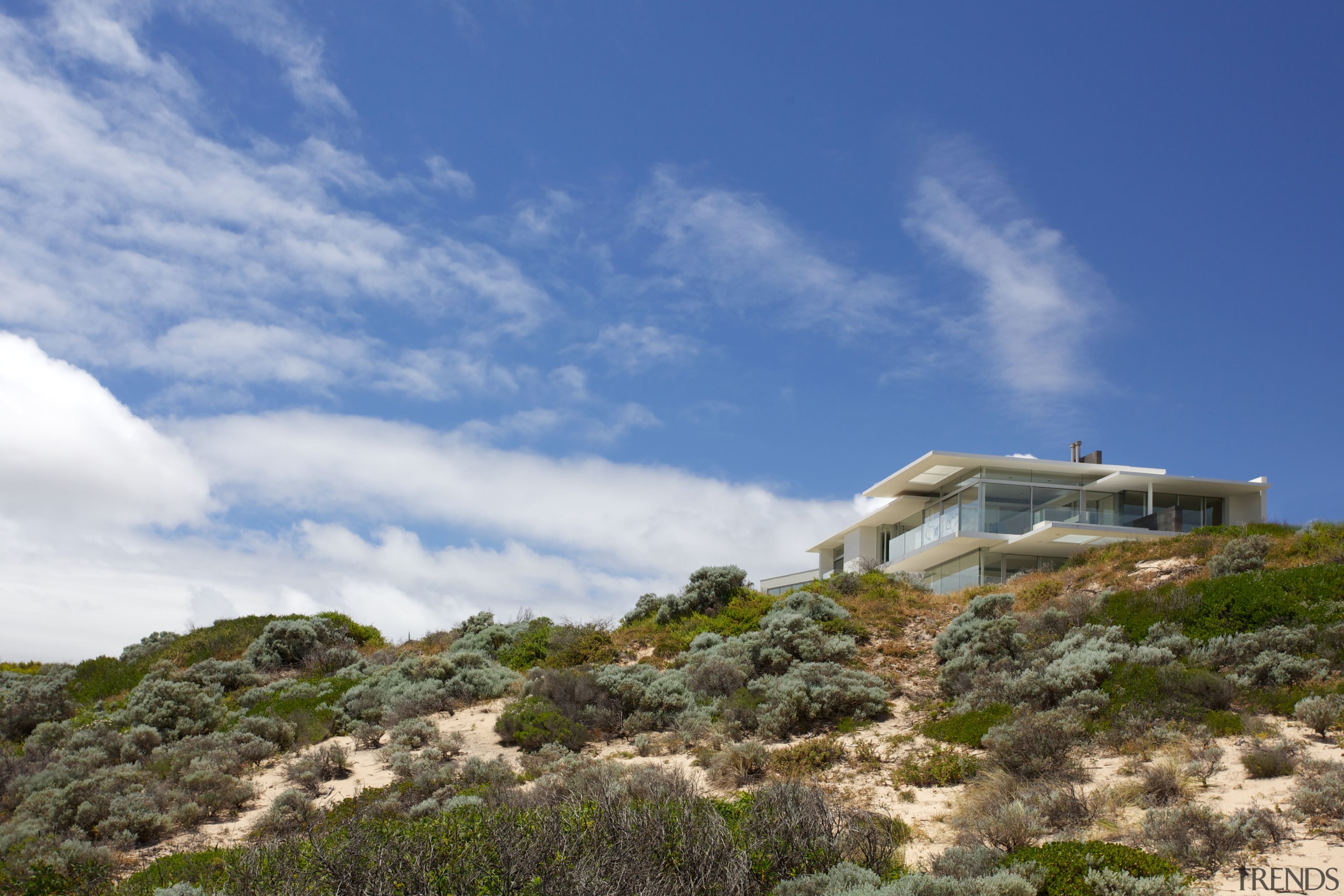 While the oceanside site provides a great outlook, cloud, coast, hill, house, mountain, plant community, real estate, shrubland, sky, terrain, blue