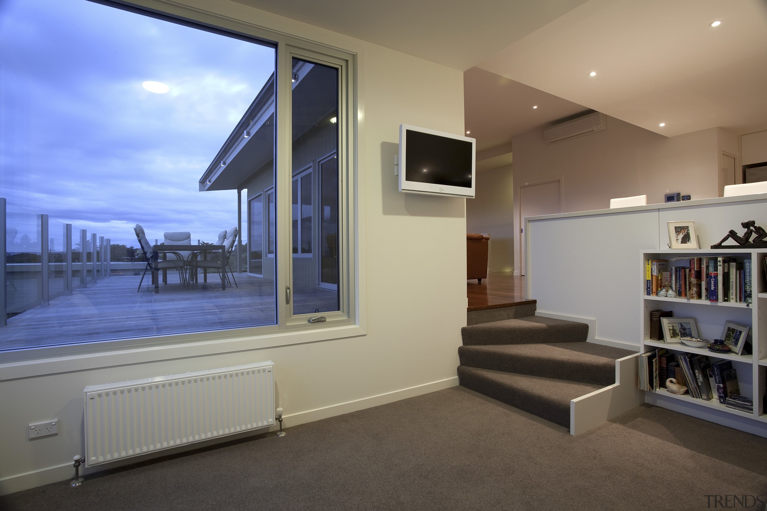 Lounge with grey flooring, cream walls and stairs. home, house, interior design, property, real estate, window