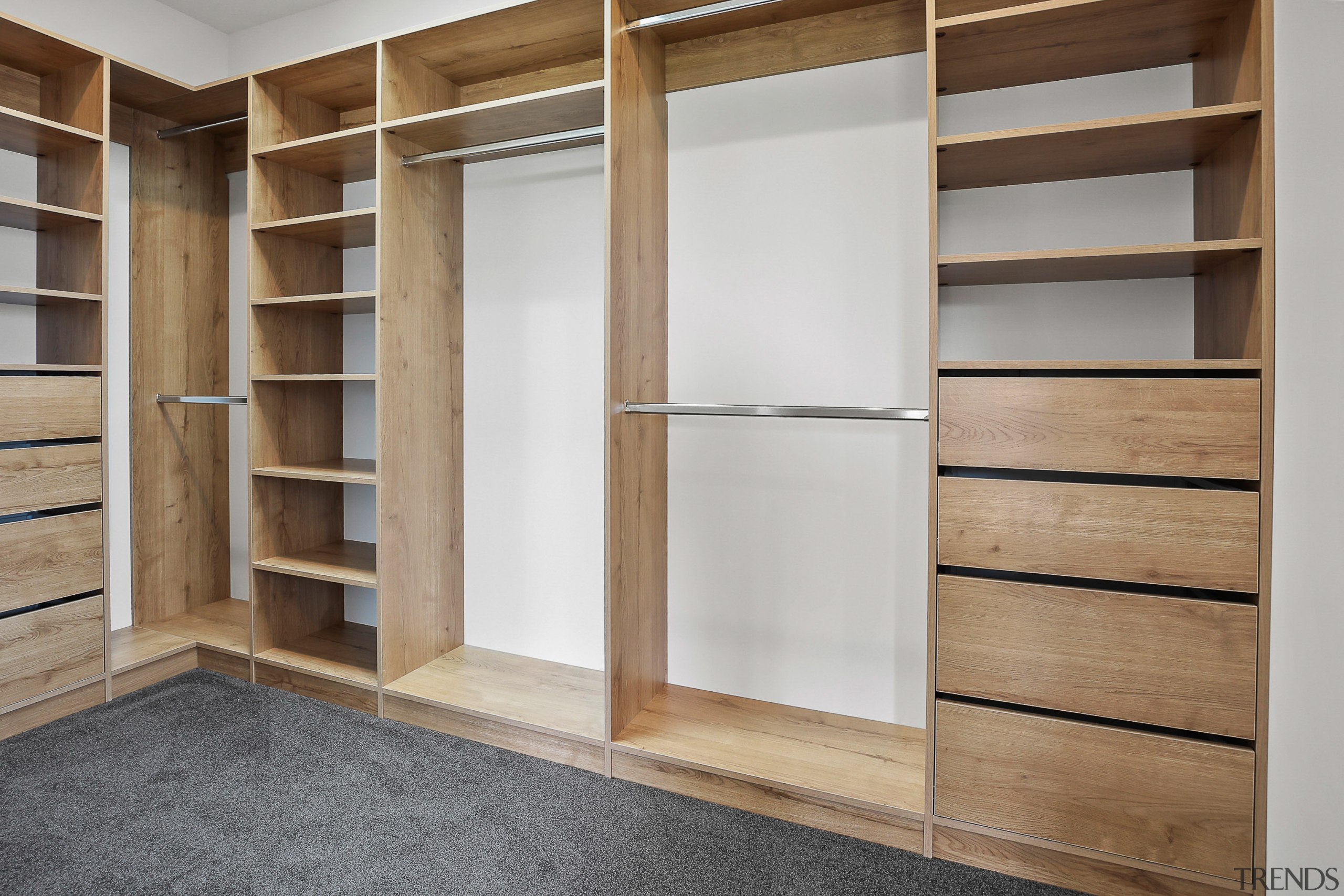 The walk-in wardrobe features comprehensive built in wood 