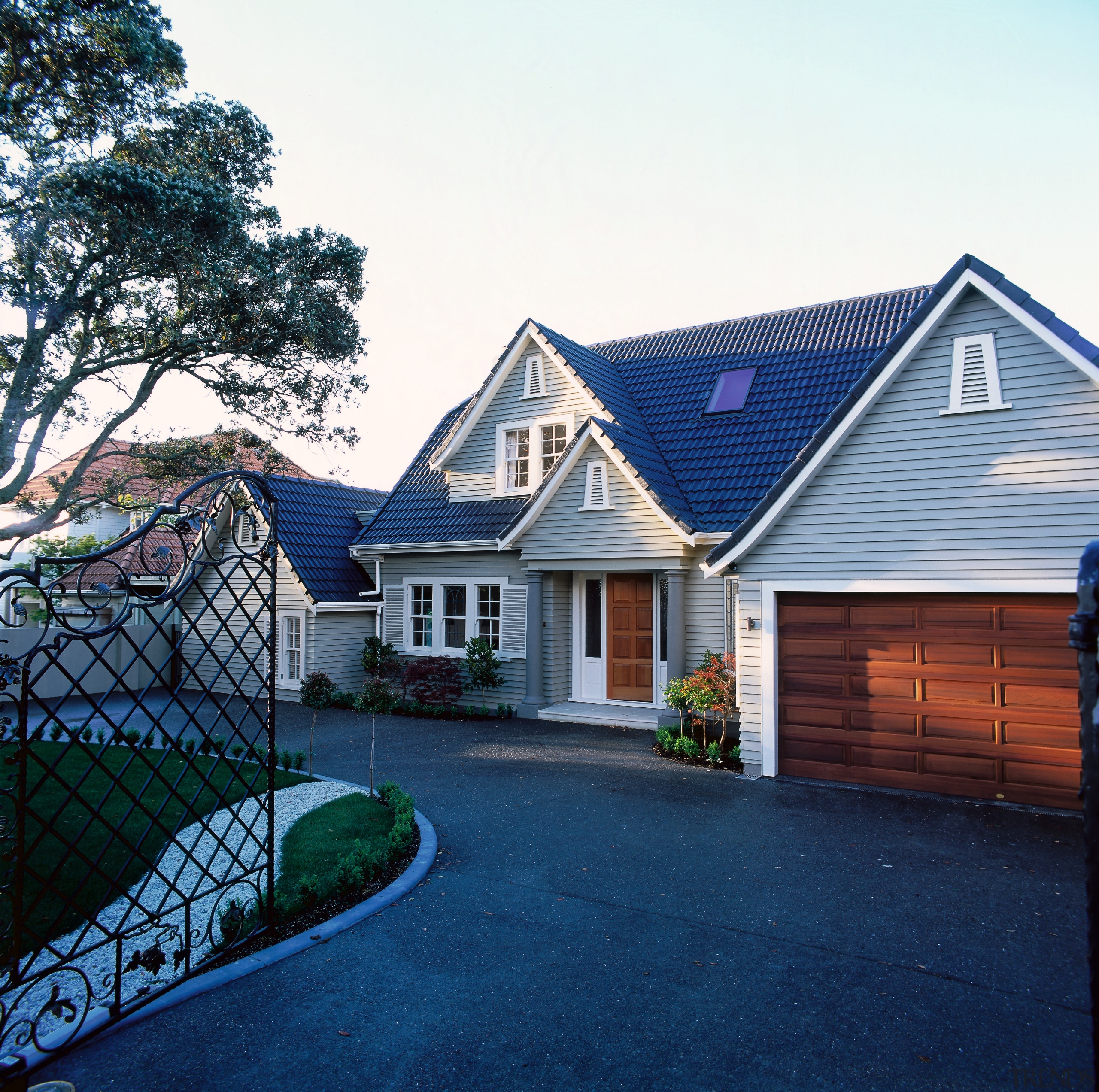 A photograph of the front of a two building, cottage, estate, facade, home, house, neighbourhood, outdoor structure, property, real estate, residential area, roof, shed, siding, suburb, window, blue, white