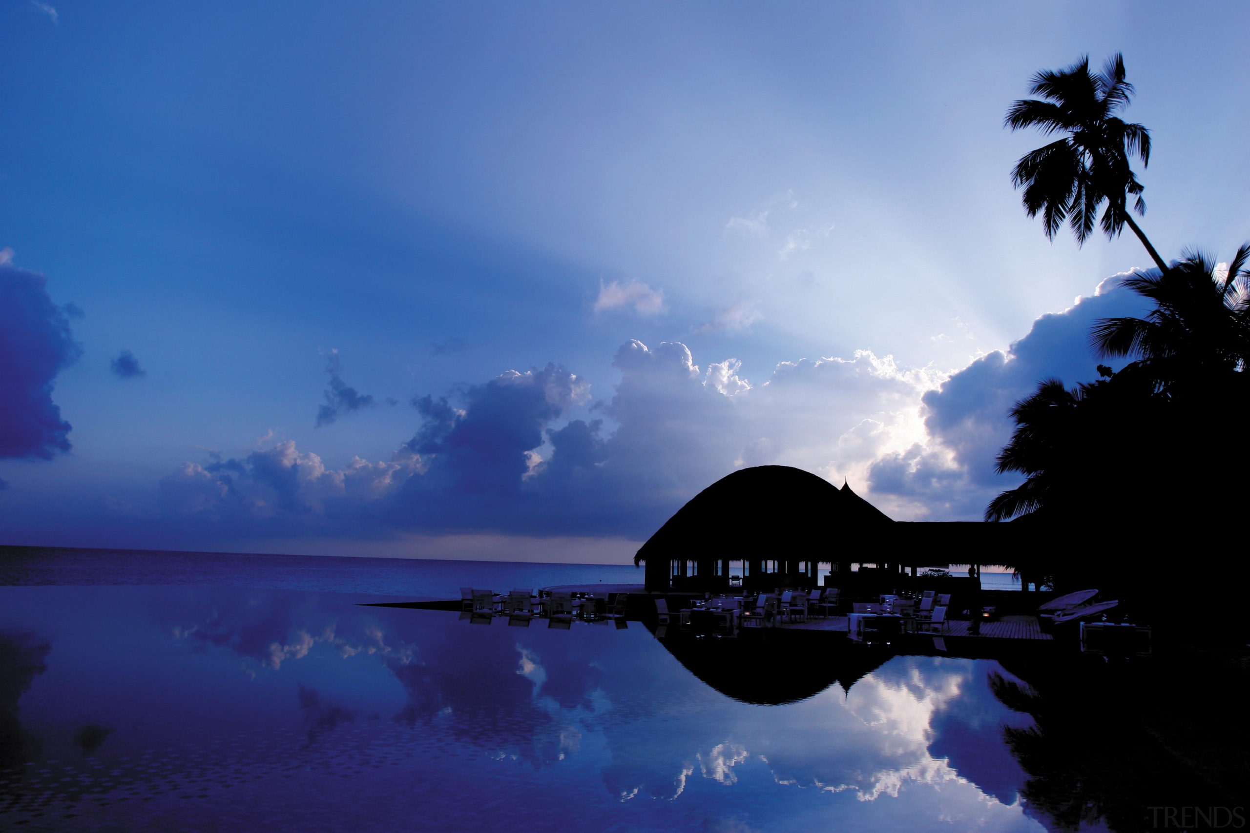 An exterior view of bungalow. - An exterior afterglow, atmosphere, calm, cloud, computer wallpaper, dawn, daytime, dusk, evening, horizon, morning, nature, ocean, phenomenon, reflection, sea, sky, sunrise, sunset, tree, tropics, water, blue