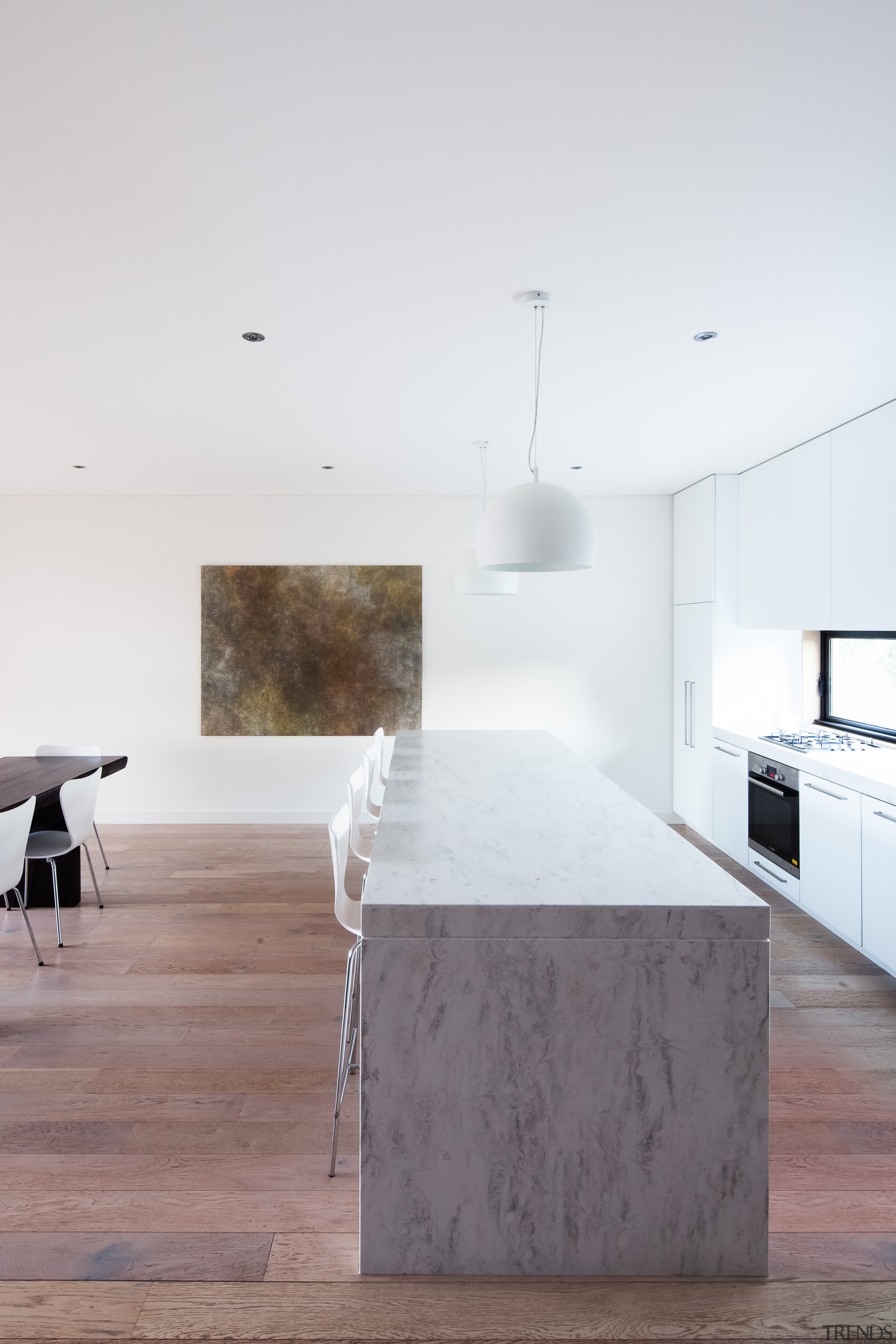 This kitchen with prominent island bench forms part architecture, building, ceiling, concrete, daylighting, design, floor, flooring, furniture, hardwood, home, house, interior design, kitchen, line, living room, loft, material property, property, room, space, table, tile, wall, white, wood, wood flooring, white, gray