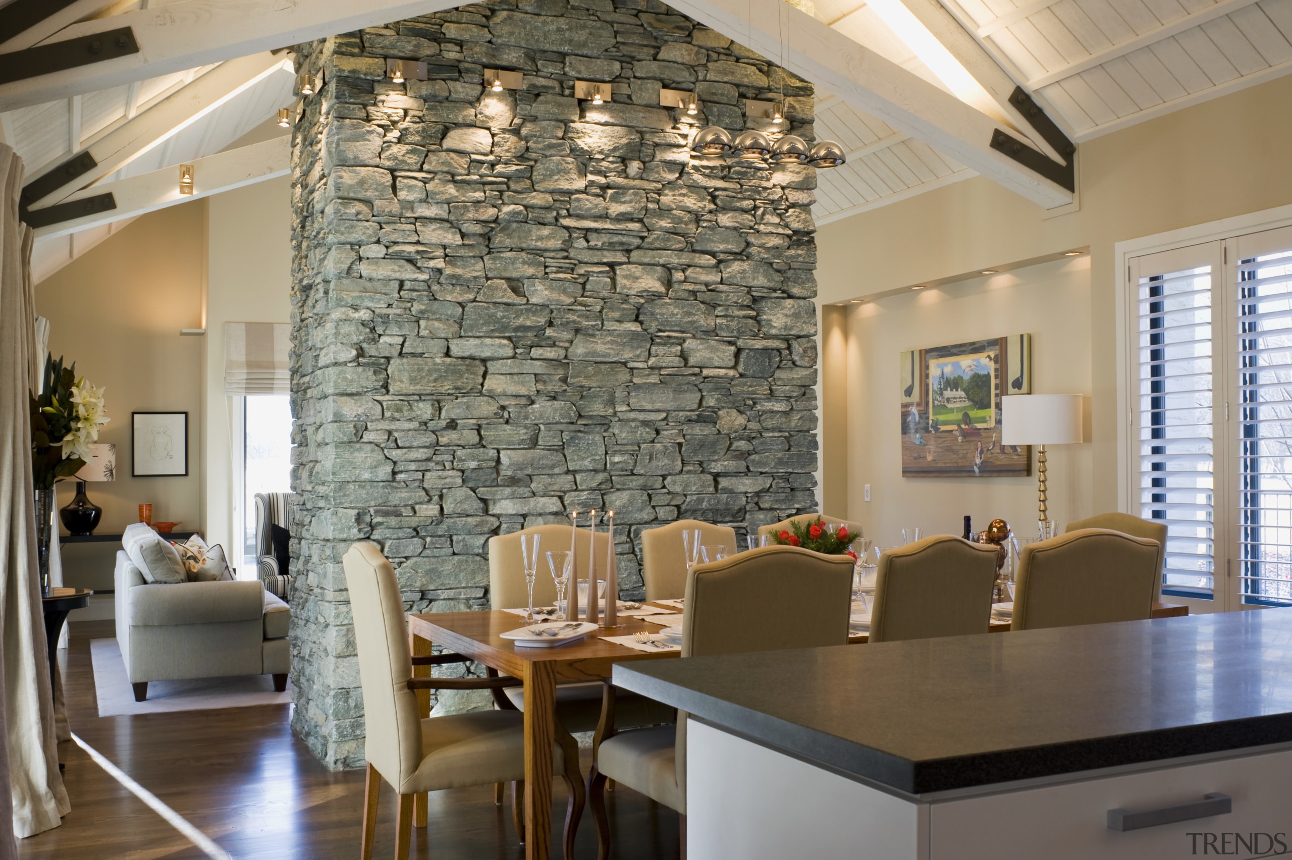 The central schist fireplace is left unadorned, as ceiling, dining room, interior design, living room, real estate, room, table, wall, gray, brown