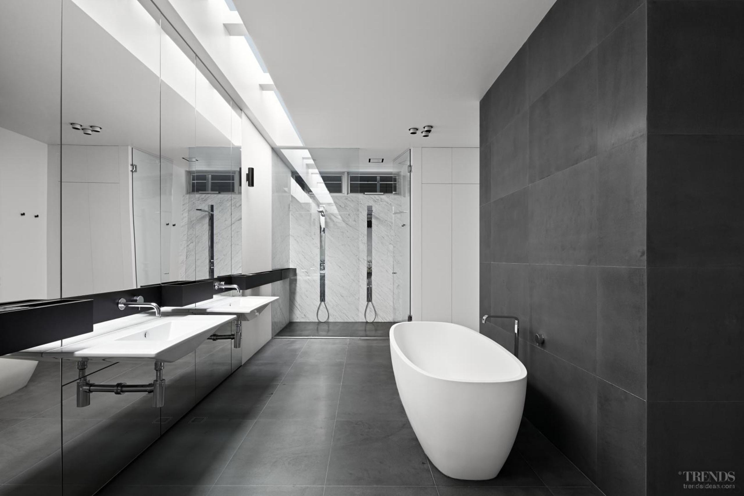 This bathroom features a mirrored wall with a architecture, bathroom, black and white, daylighting, floor, interior design, monochrome, monochrome photography, plumbing fixture, room, tile, gray, black