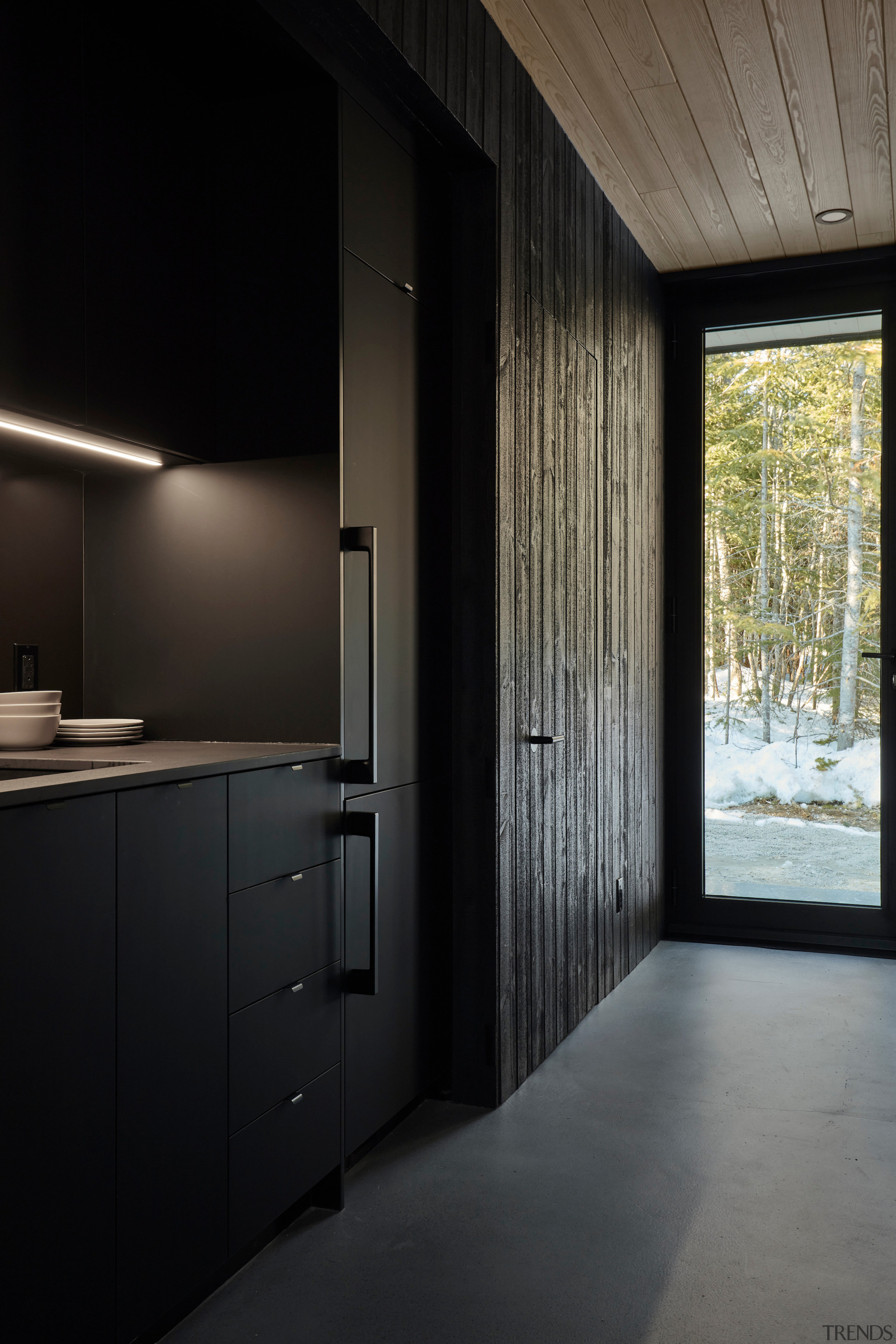 The kitchen continues the pared back black interior, 