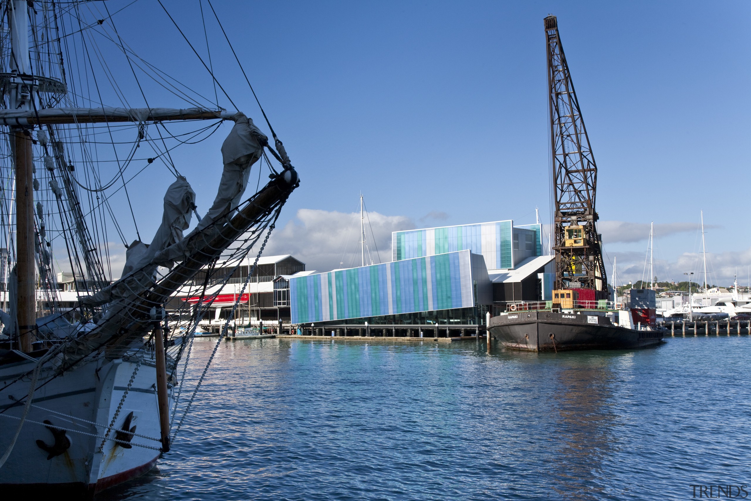 A yellow tower element signposts the museum building bridge, drawbridge, harbor, port, sea, ship, sky, water, teal, blue