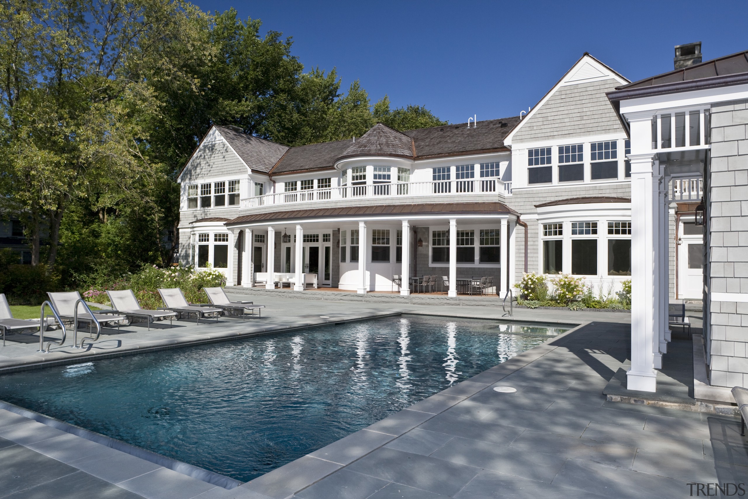 View of the homes exterior featuring stained cider backyard, estate, home, house, mansion, outdoor structure, property, real estate, residential area, swimming pool, villa, window, gray