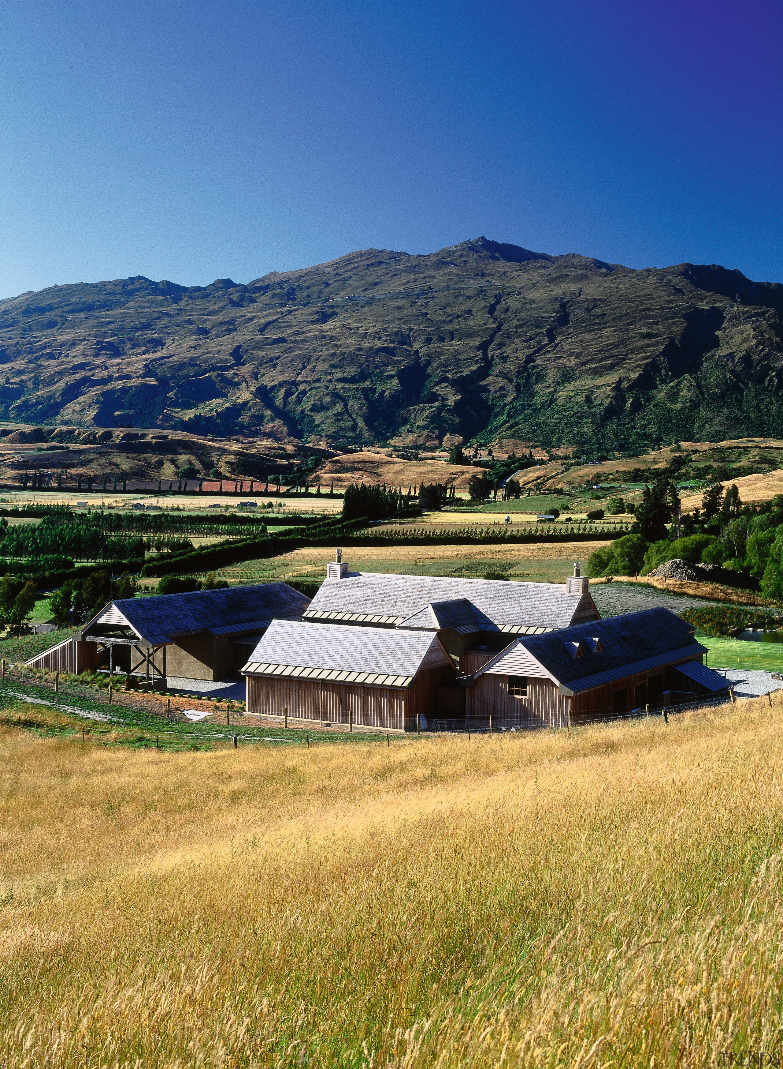 An exterior view of this rural farmstead house farm, fell, field, grass, grassland, highland, hill, home, house, hut, landscape, meadow, mount scenery, mountain, mountain range, mountainous landforms, national park, pasture, real estate, rural area, sky, sunlight, village, wilderness, blue