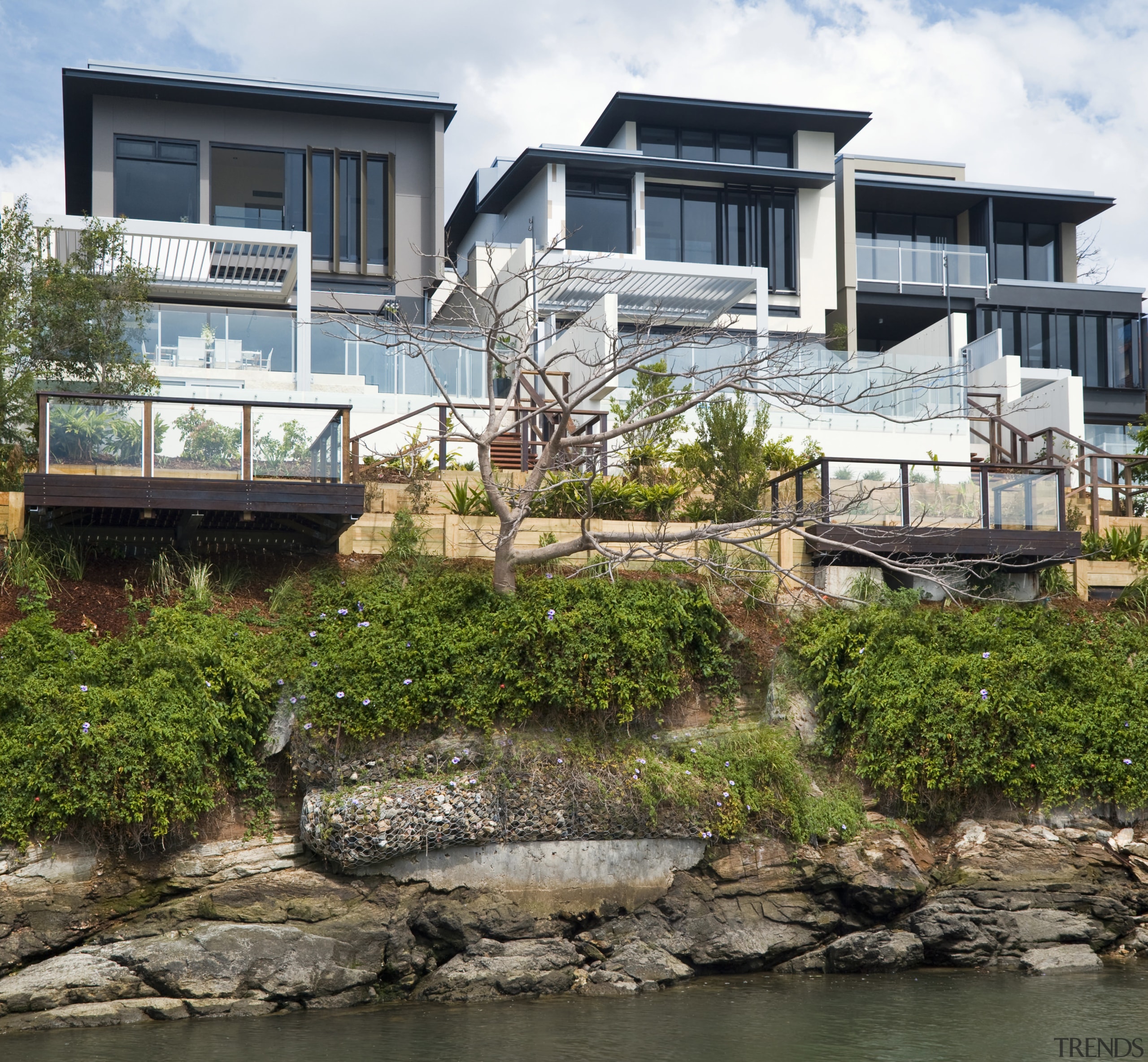 View of the Norman Reach development which is architecture, building, condominium, cottage, home, house, plant, property, real estate, tree, water, waterway, brown, white