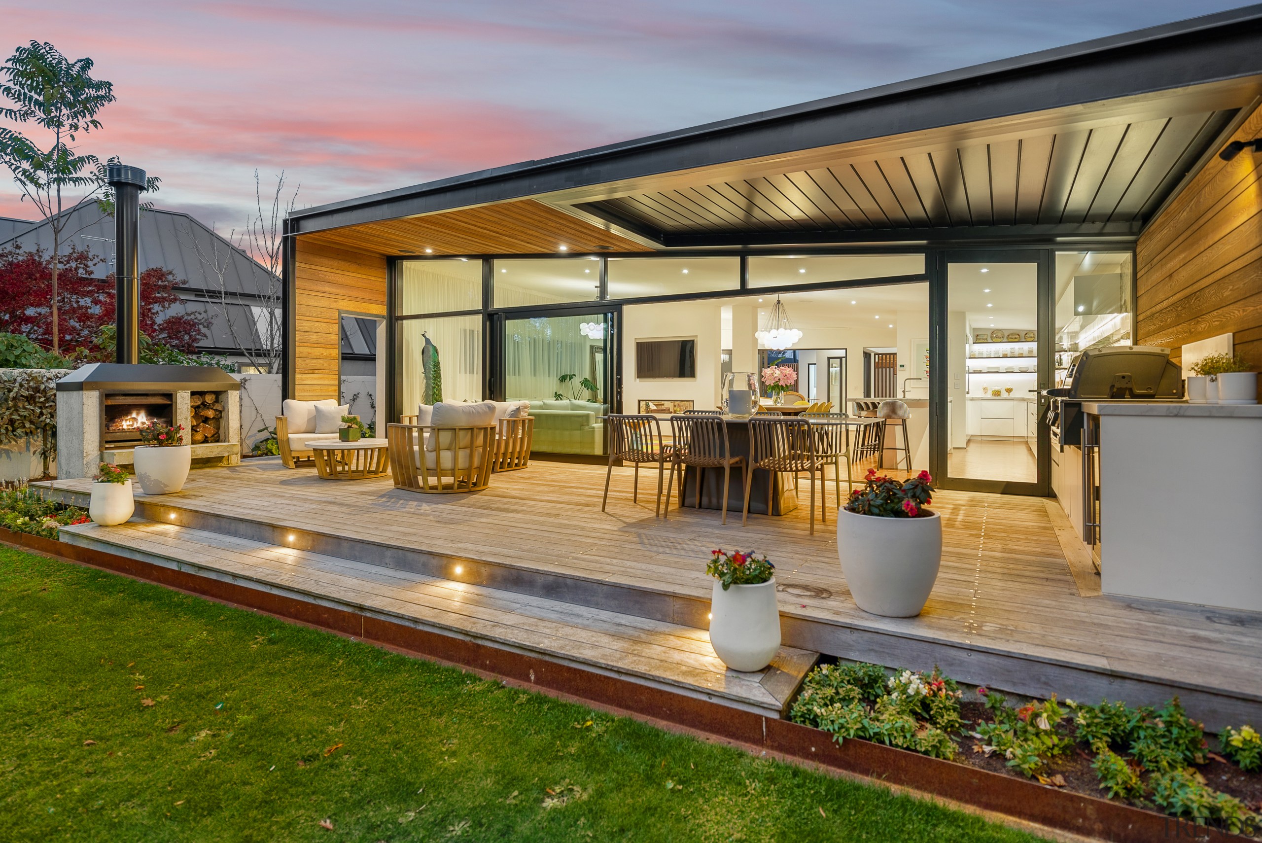 Kitchen, living spaces, and outdoor living at dusk. 