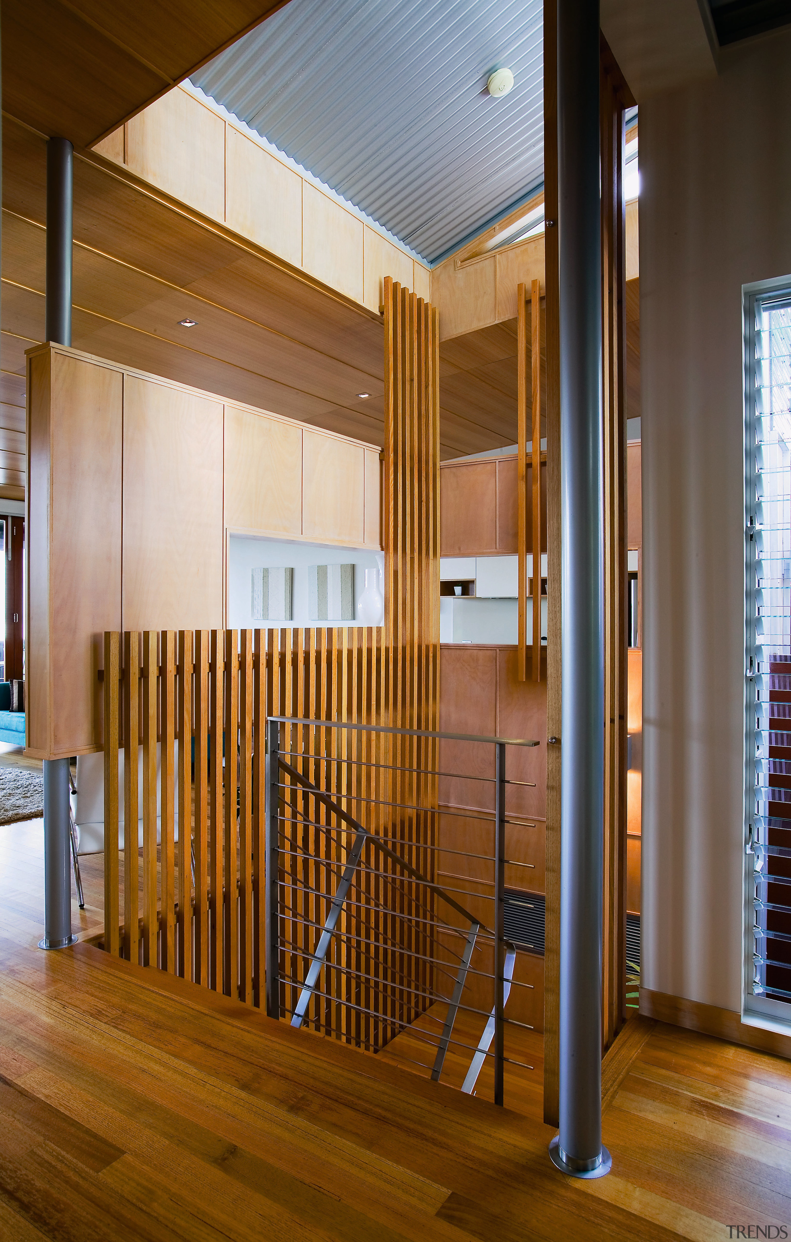 view of the hall/stairway featuring timber flooring, steel architecture, ceiling, floor, flooring, hardwood, house, interior design, lobby, real estate, stairs, wood, wood flooring, brown