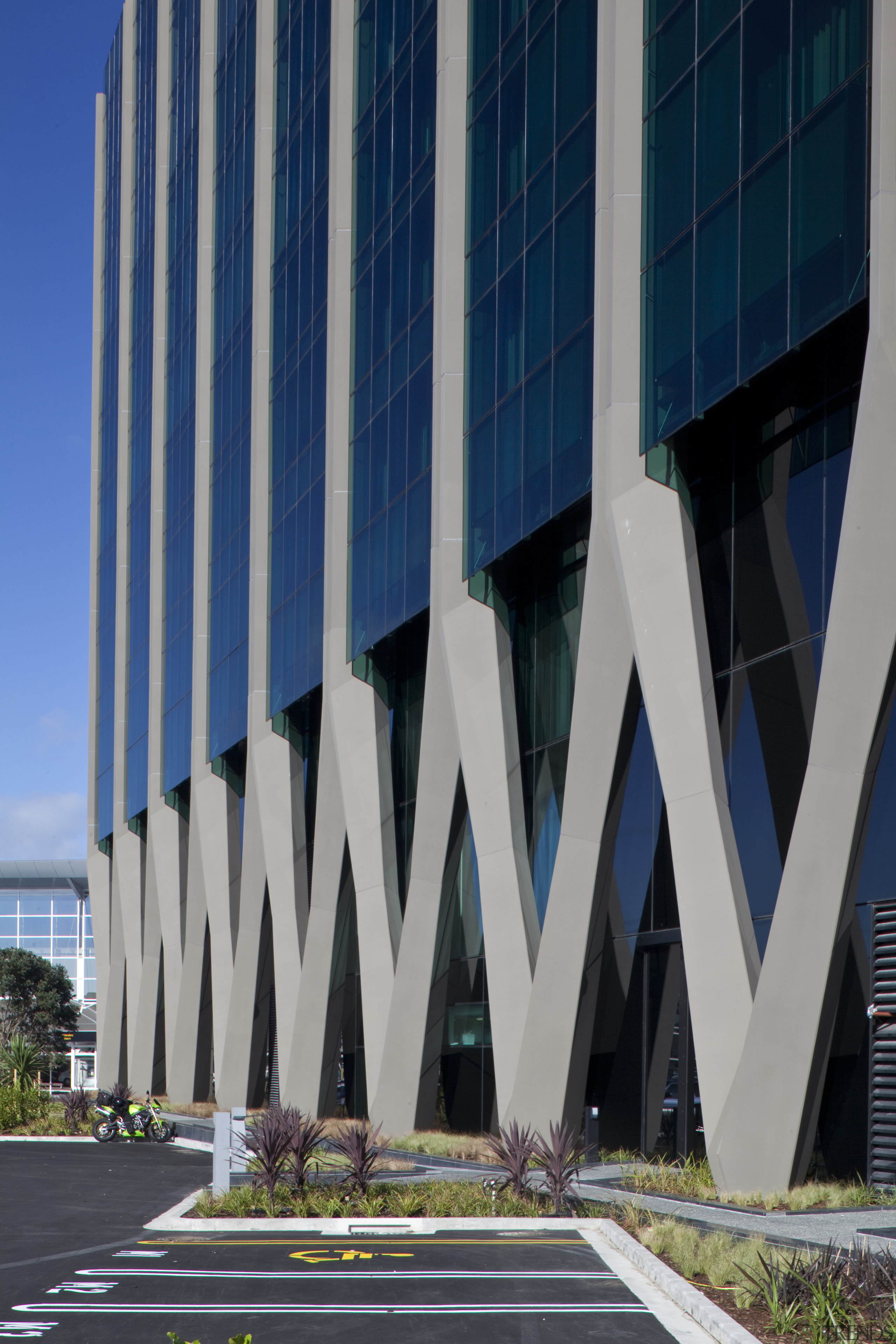 The Novotel Auckland Airport hotel's intricate concrete structure architecture, building, commercial building, condominium, corporate headquarters, daytime, facade, headquarters, landmark, line, metropolis, metropolitan area, mixed use, sky, skyscraper, structure, tower block, urban area, gray, blue