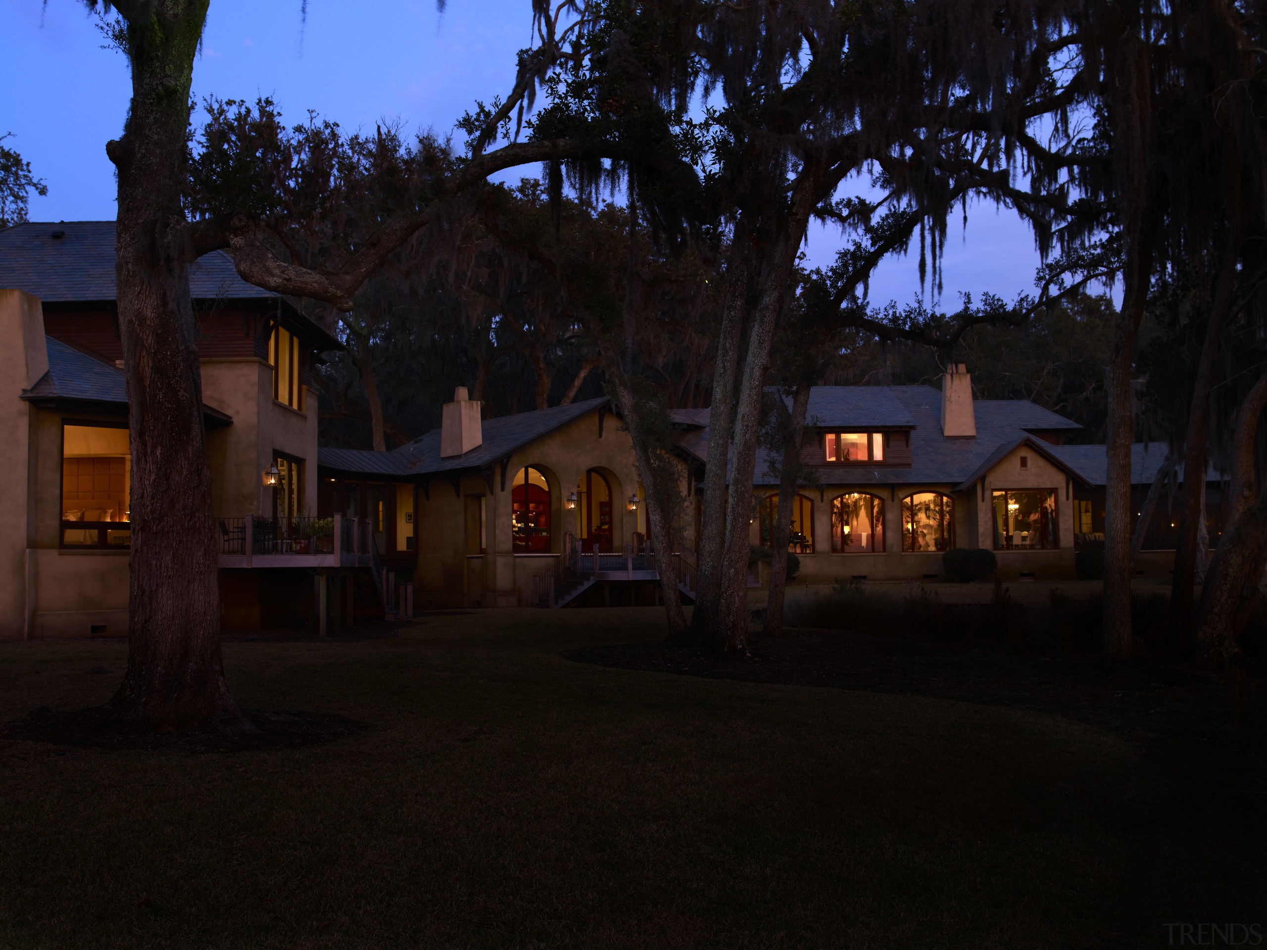 Exterior night shot of house with landscaping. - cottage, darkness, estate, evening, home, house, landscape lighting, light, lighting, night, property, real estate, residential area, sky, town, tree, black