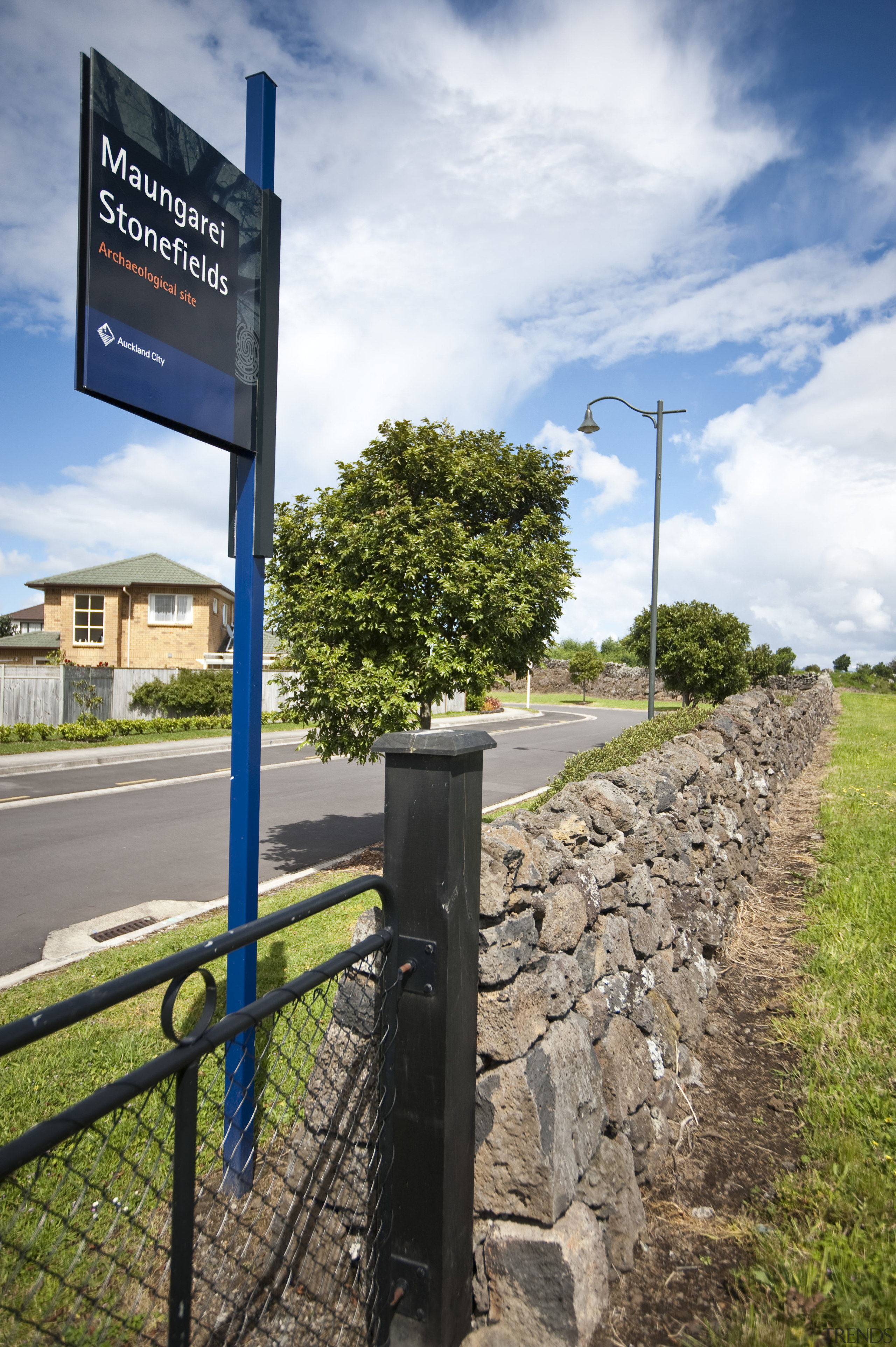 View of Mt Wellington stone walls. - View cloud, grass, infrastructure, lane, path, road, sign, signage, sky, street sign, traffic sign, tree, white