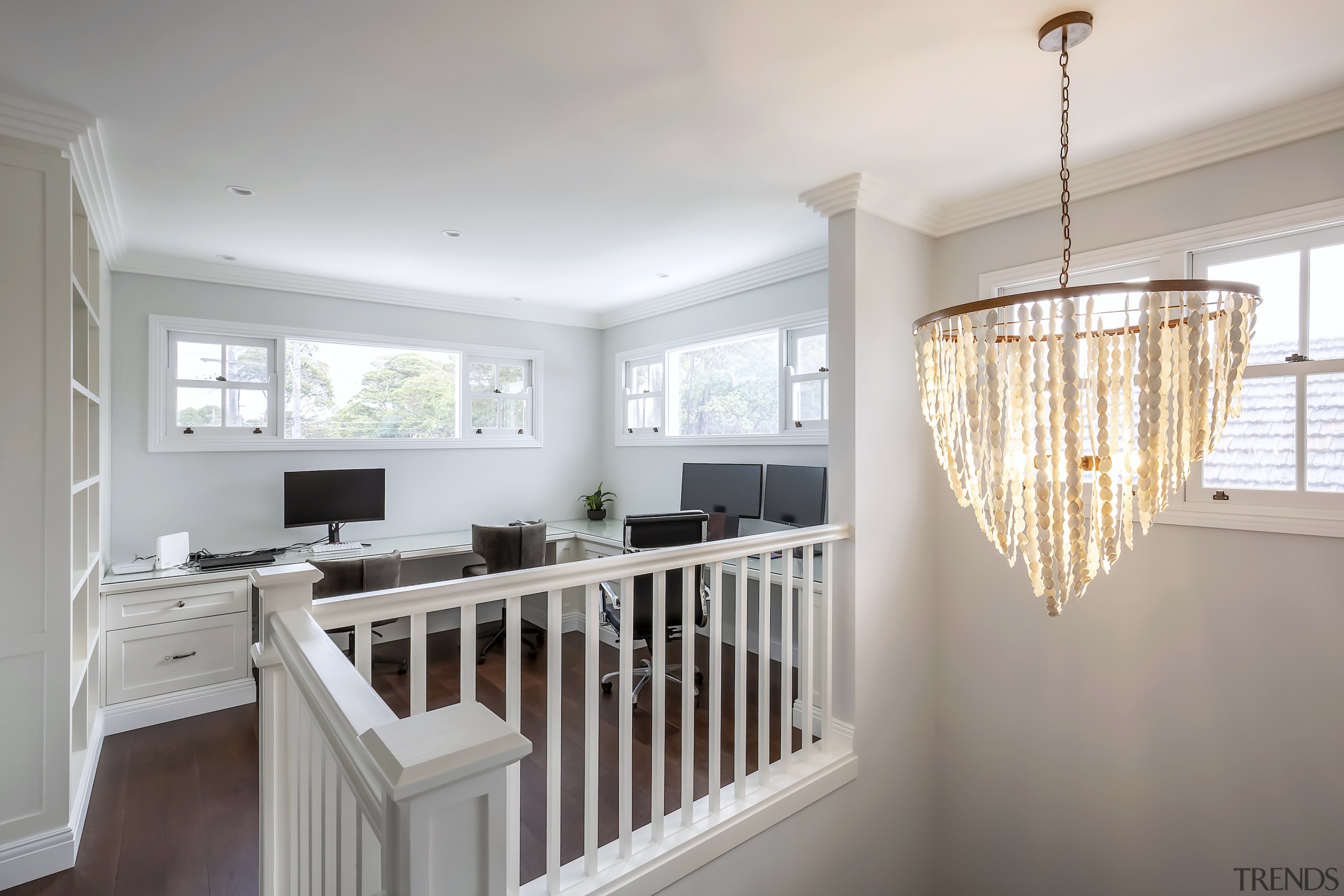 A gracious chandelier accentuates the crafted upstairs-downstairs connection. 