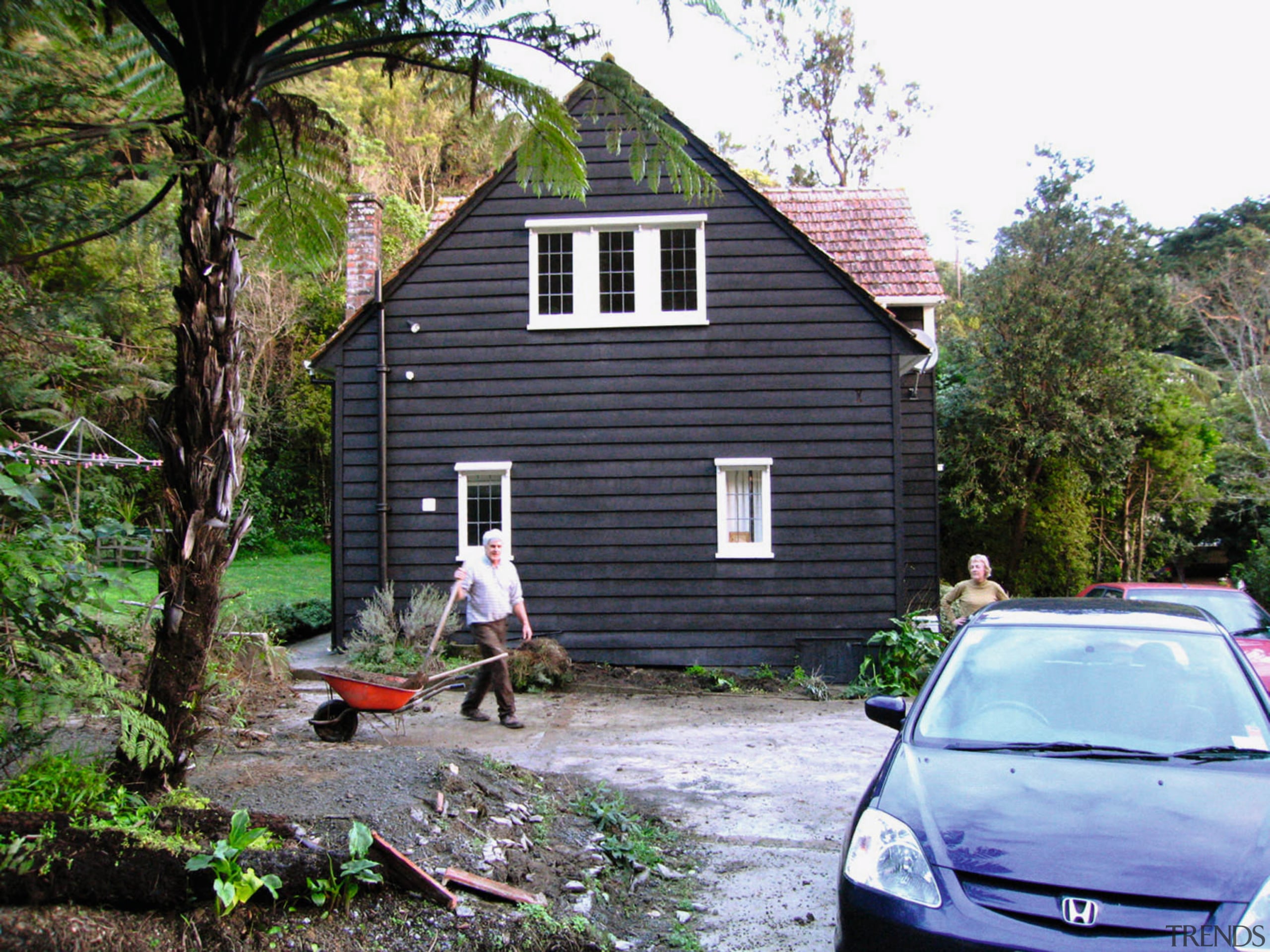 Previously, this home had minimal windows on its backyard, cottage, home, house, plant, property, real estate, roof, shed, siding, tree, yard